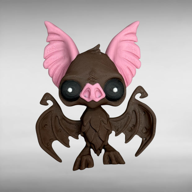 Toy figure of a brown bat with pink ears and nose on a gray background