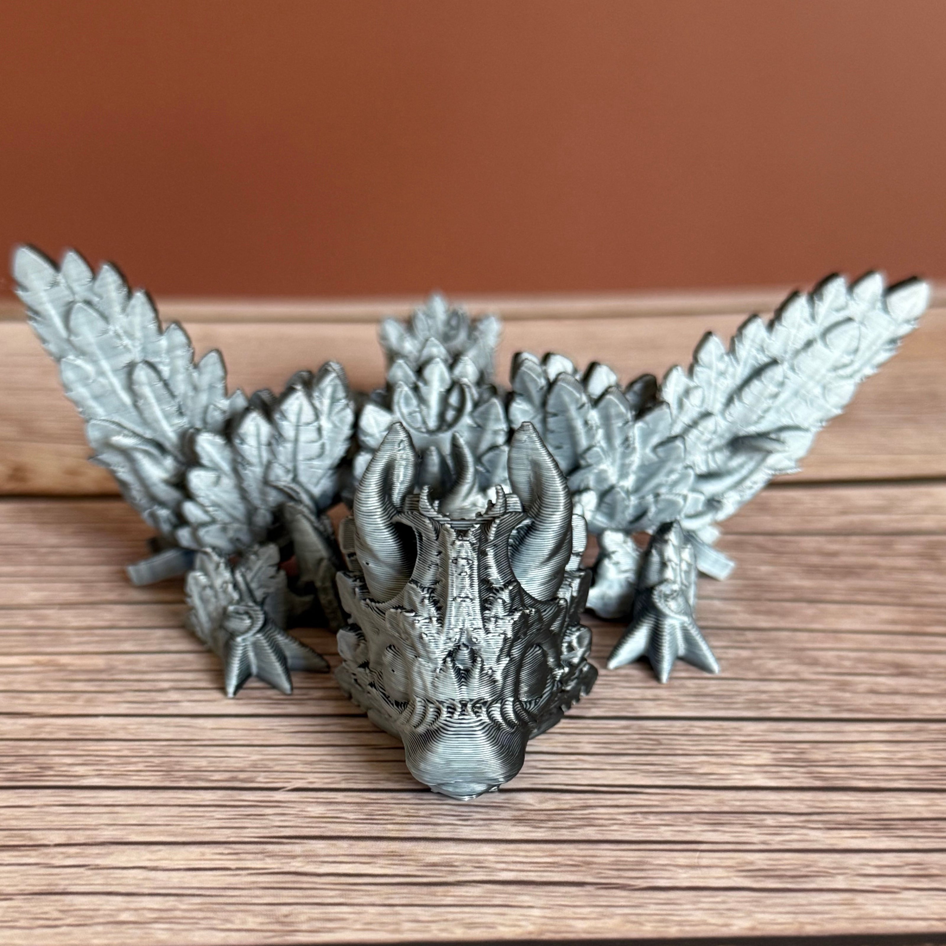 A 3D printed, articulated dragon toy with black and white celestial-inspired patterns on a wooden surface.
