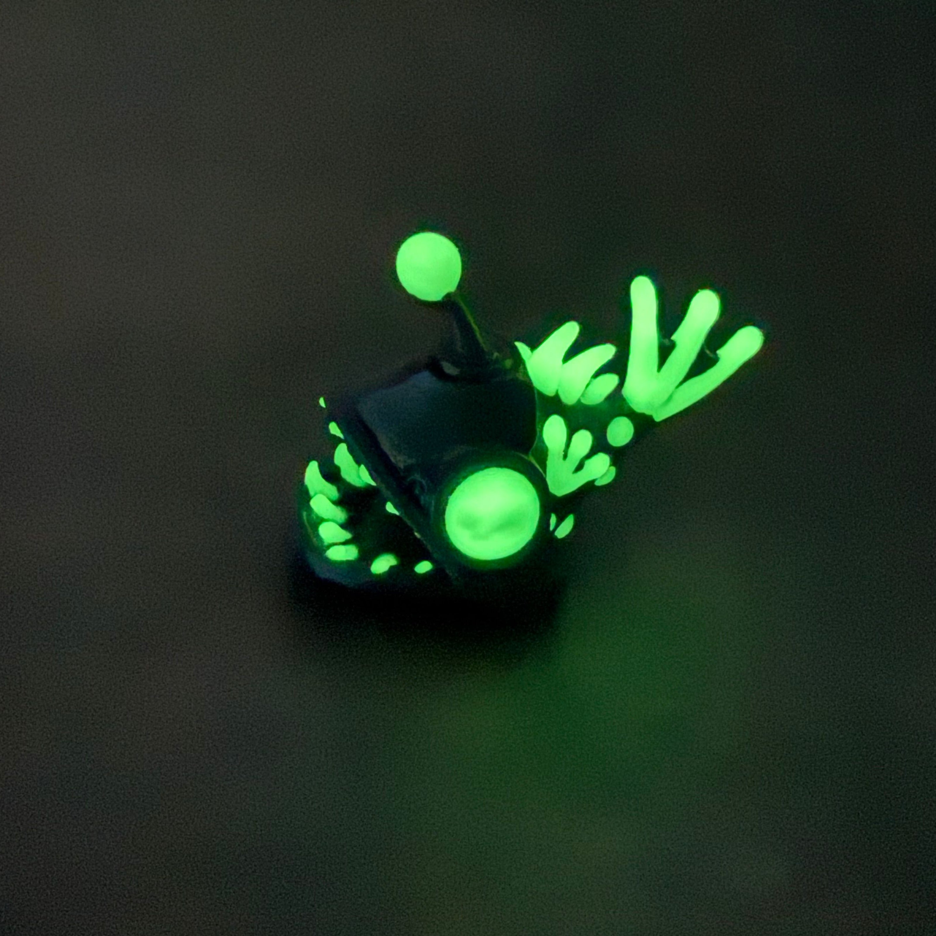 angler fish figure with glowing eyes and glowing accents on a dark background