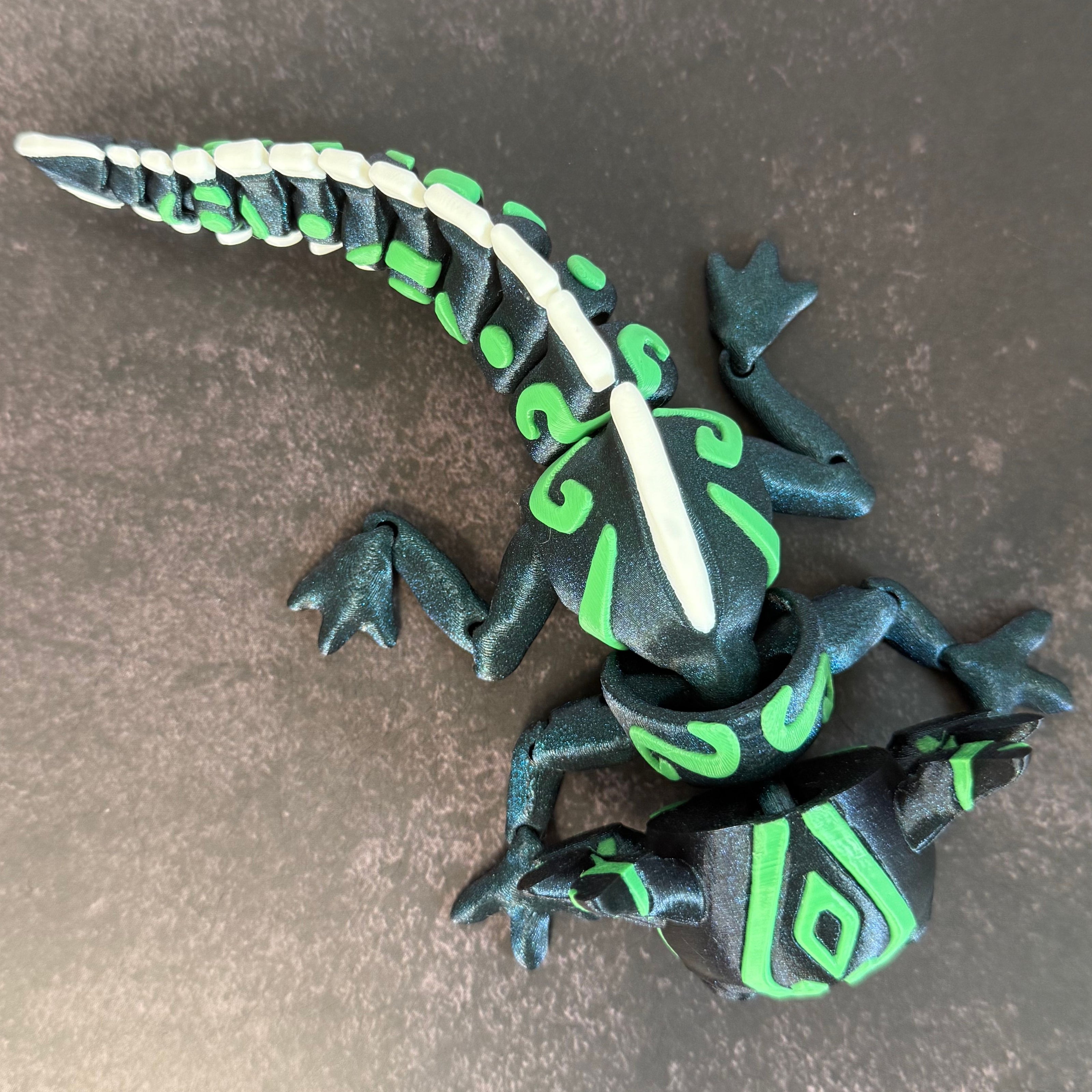 toy axolotl figure with blue, green, and white markings on a black and gray background