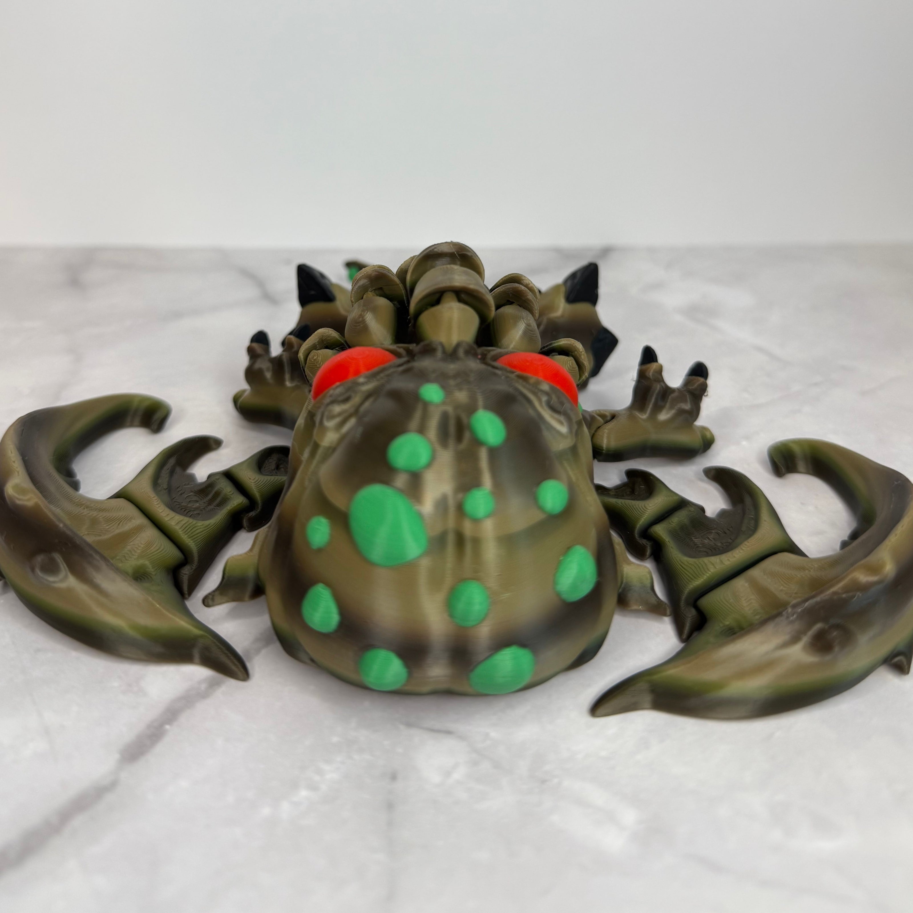 Toy figure of a creature with red eyes and green accents on a gray background