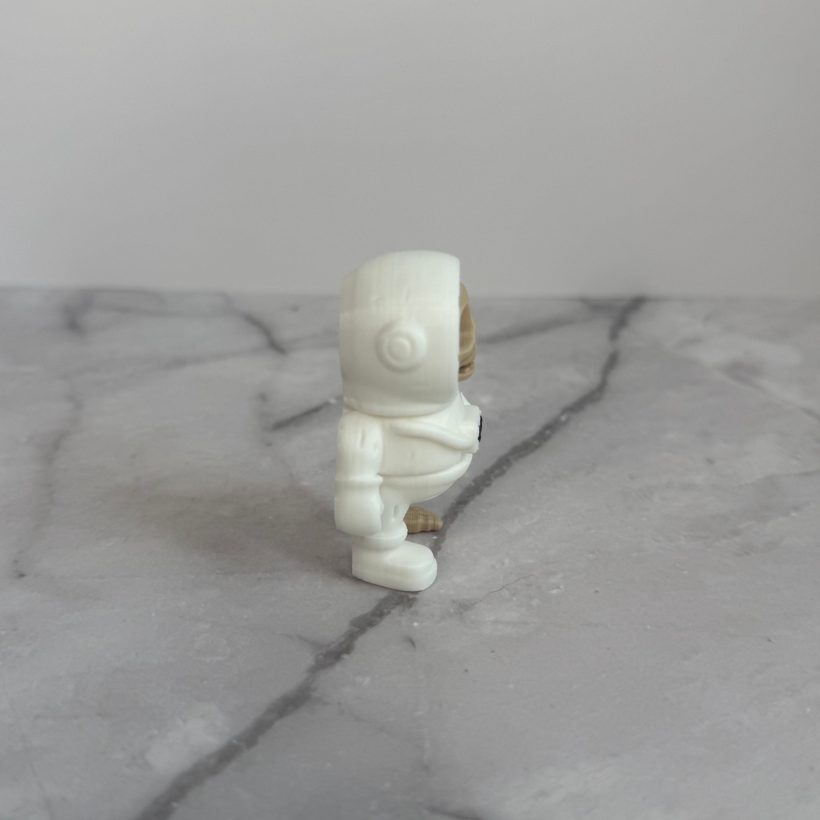 Small figure of a skeleton in an astronaut suit on a light gray background