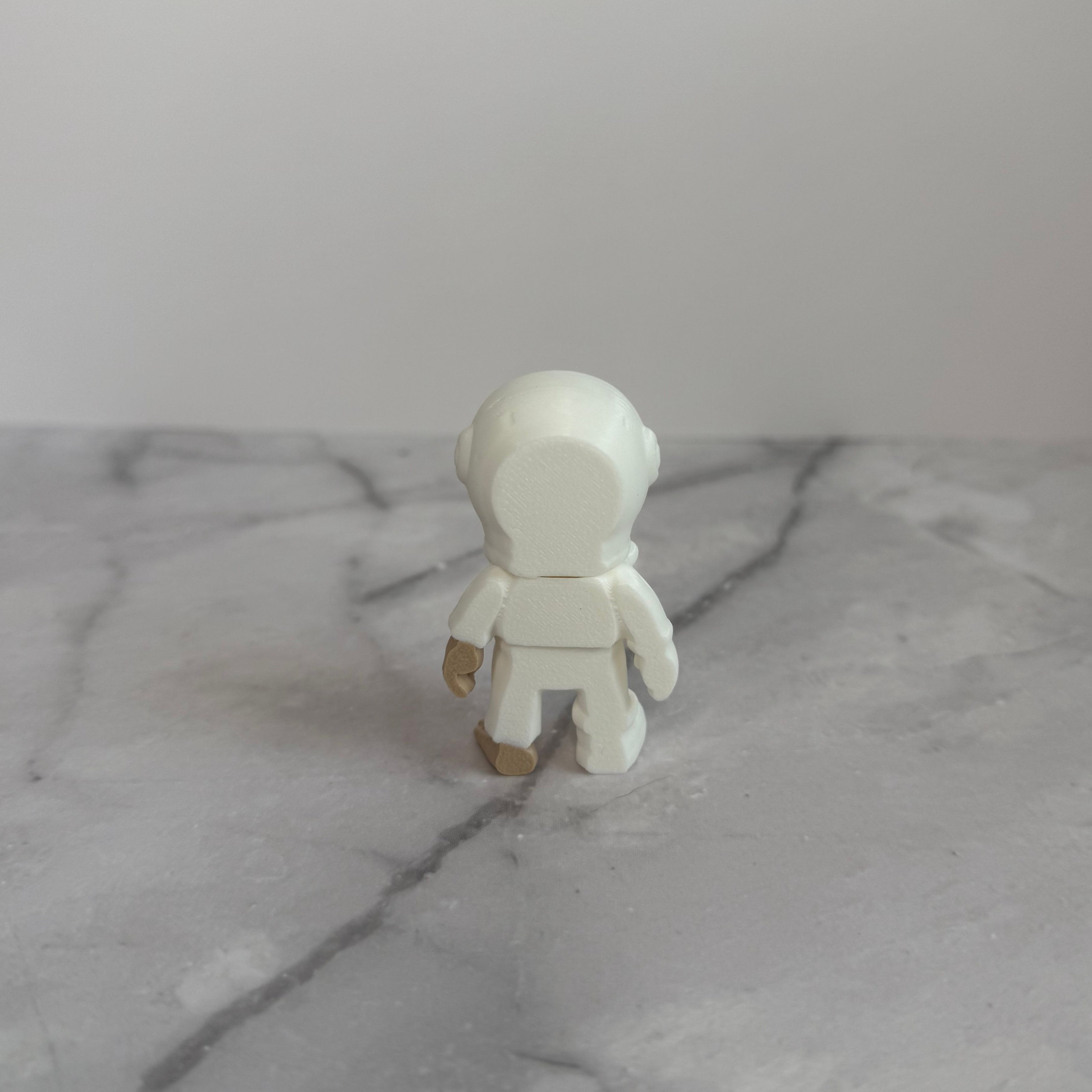 Small figure of a skeleton in an astronaut suit on a light gray background