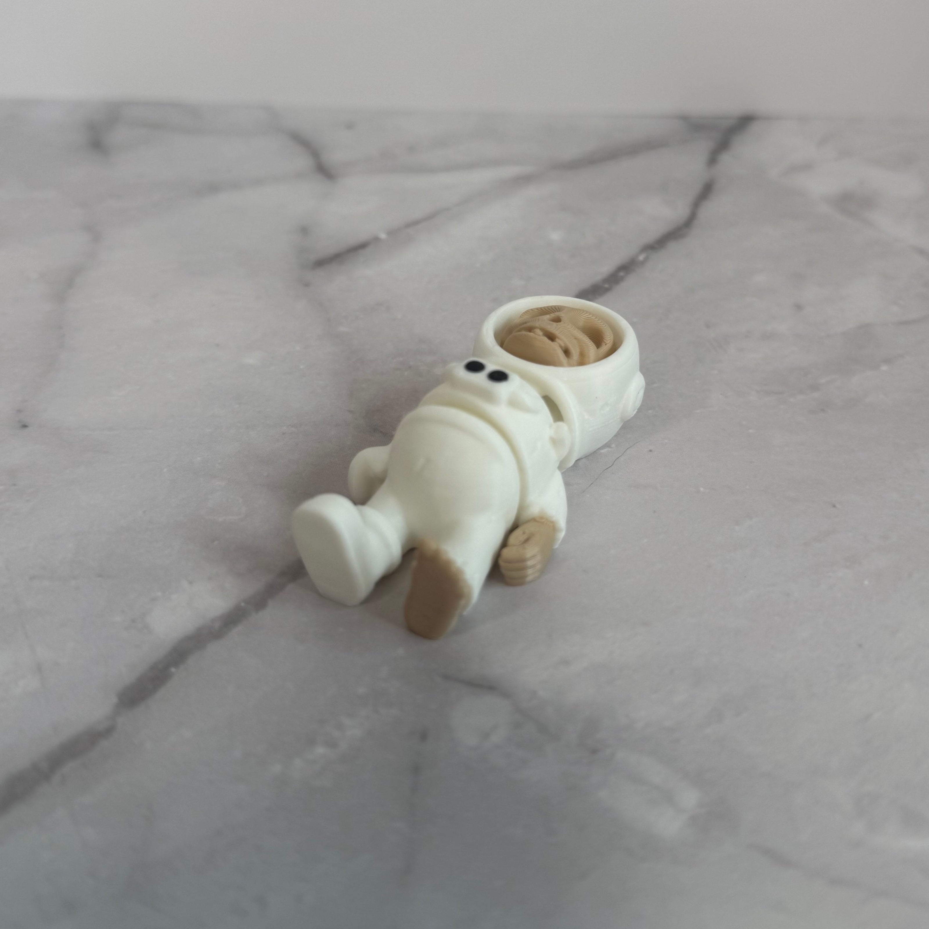 Small figure of a skeleton in an astronaut suit on a light gray background