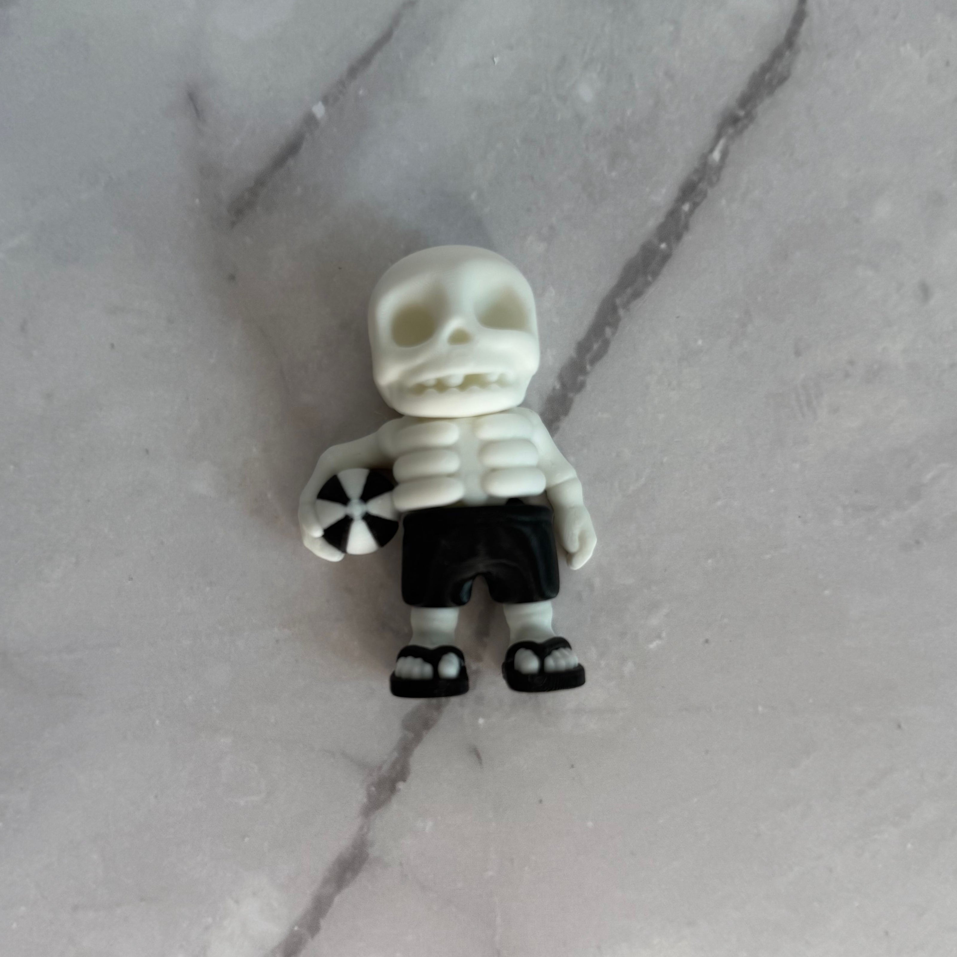Skeletal figure with a beach ball on a gray background