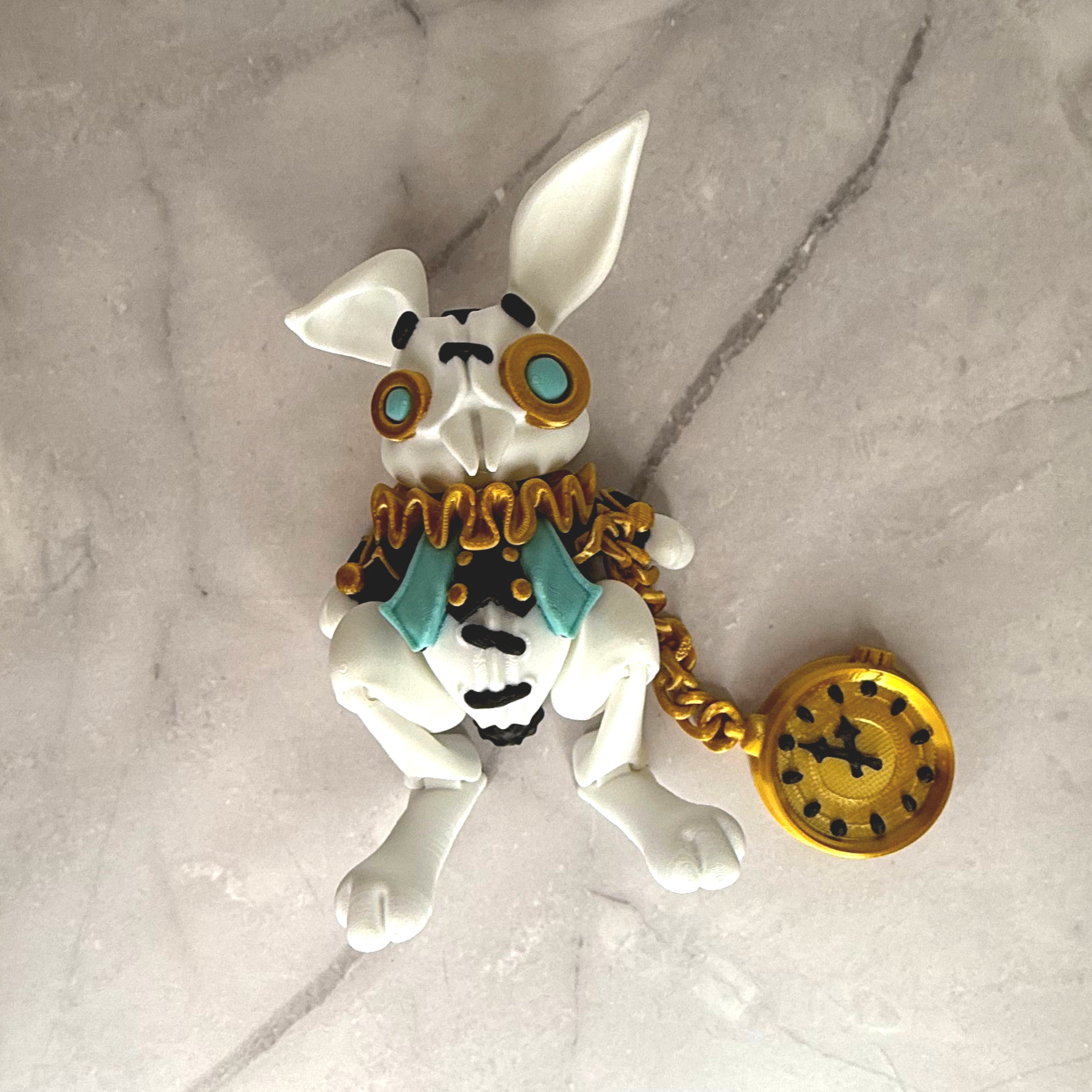 White rabbit figurine with gold and black accessories on a gray background