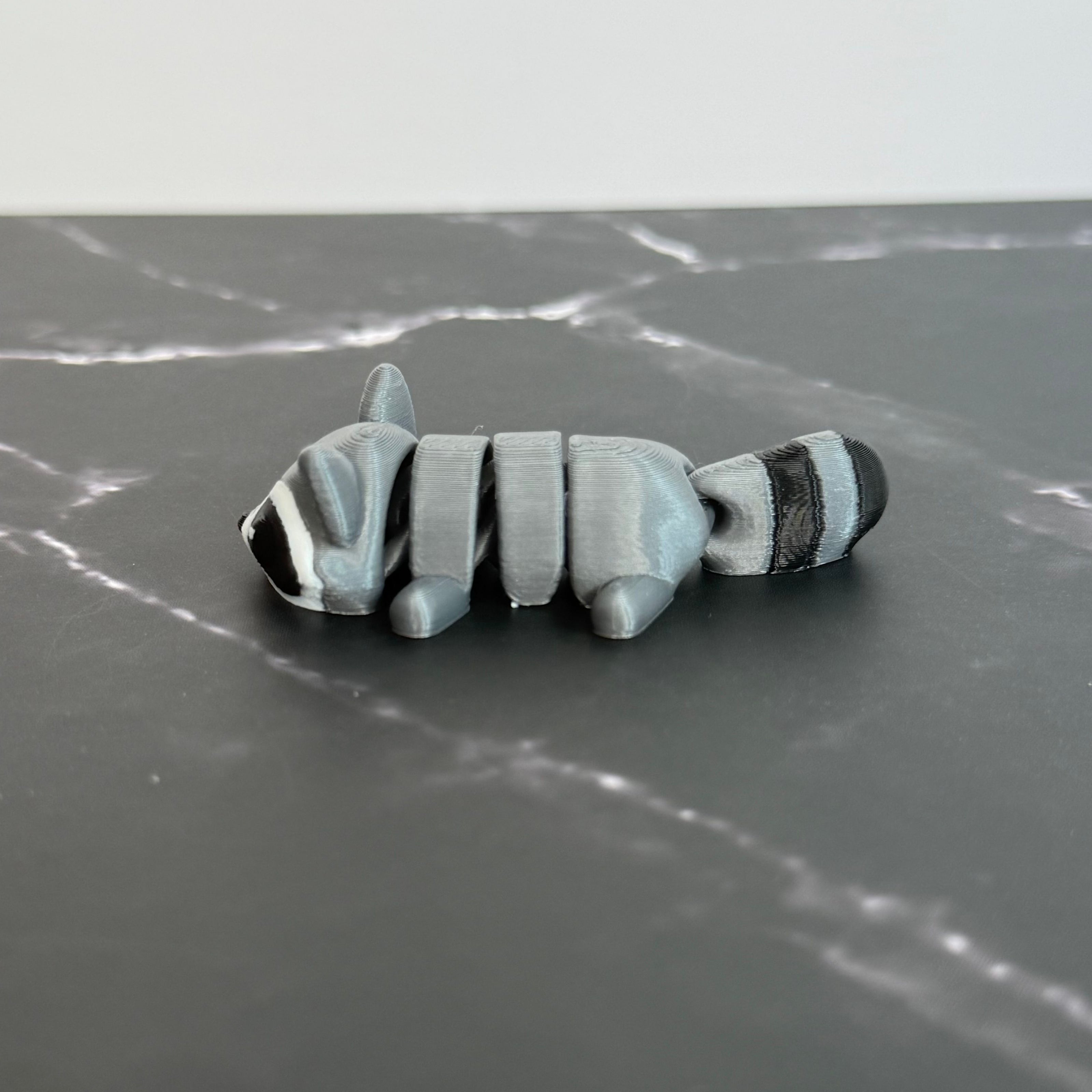 Toy raccoon figure on a marble surface