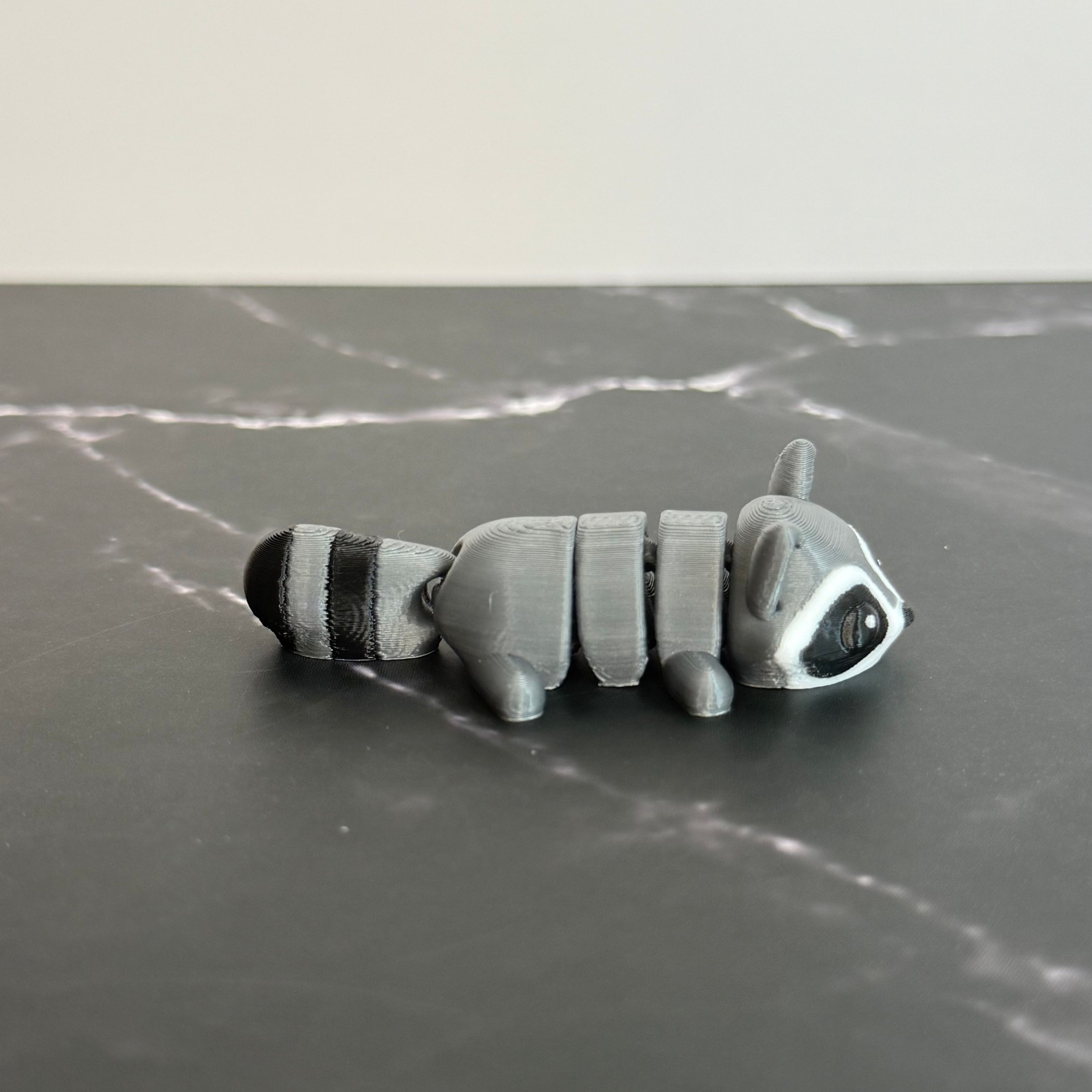 Toy raccoon on a gray marble surface