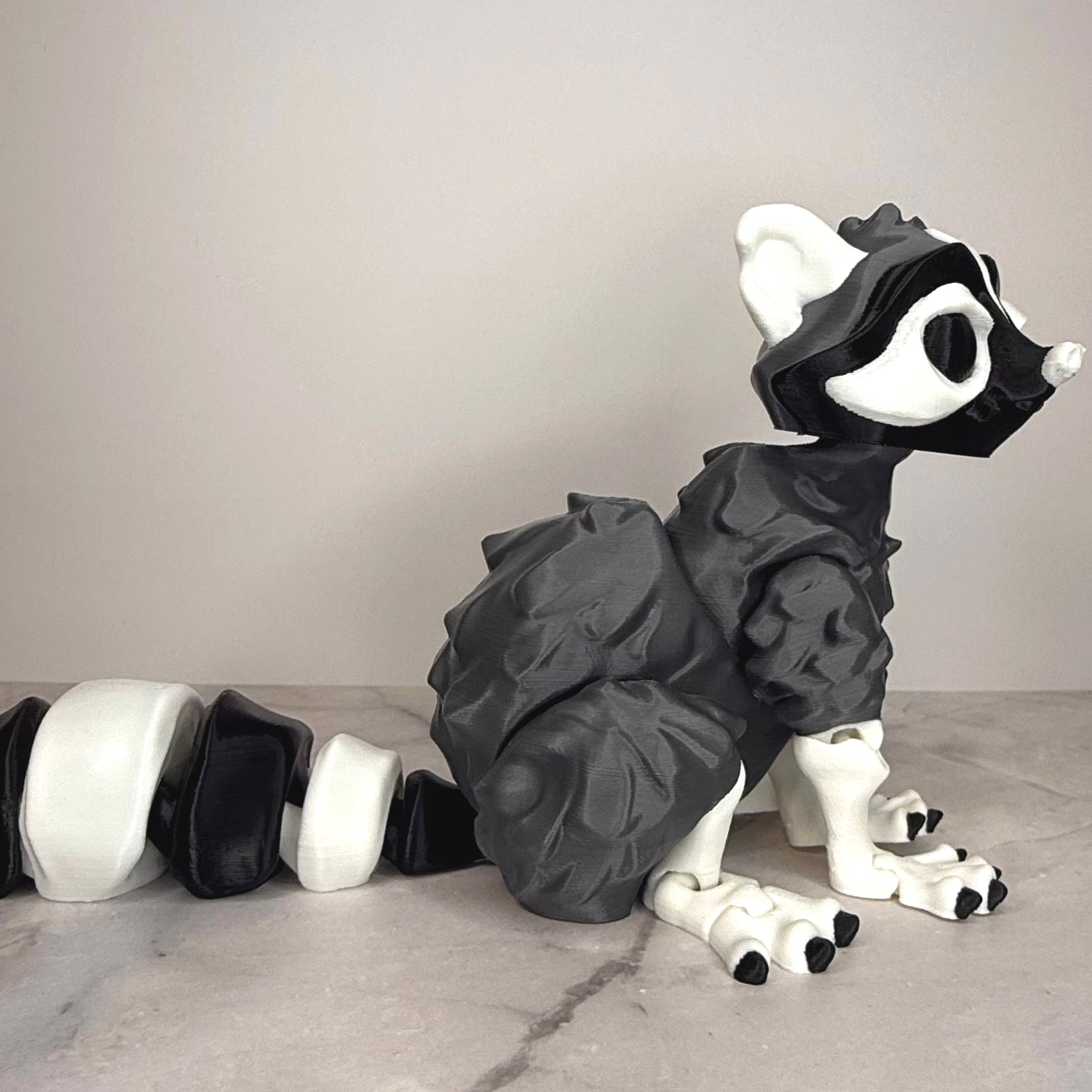 Black and white toy figure of a creature on a gray surface with a neutral background