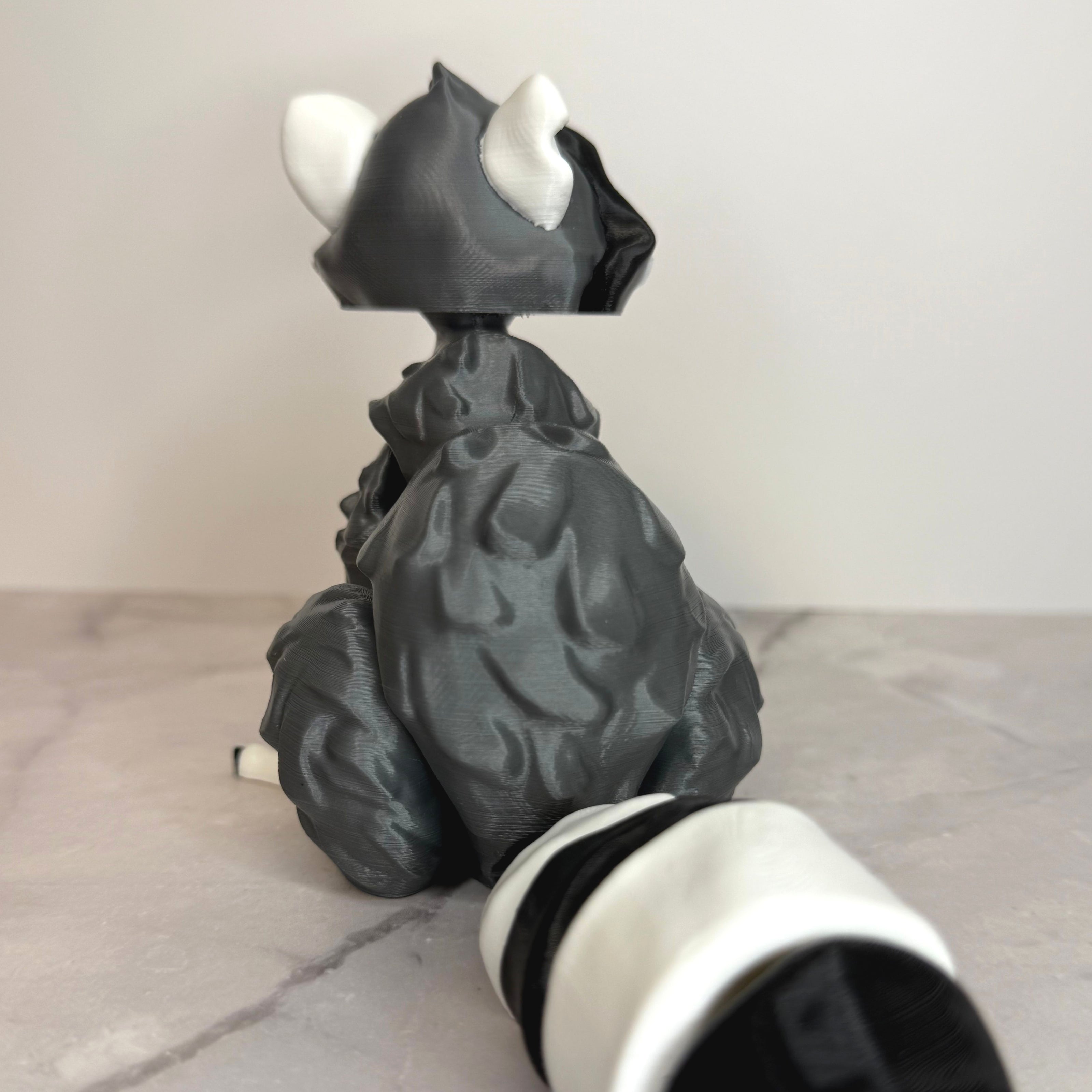 Back of racoon-shaped figure on a gray background