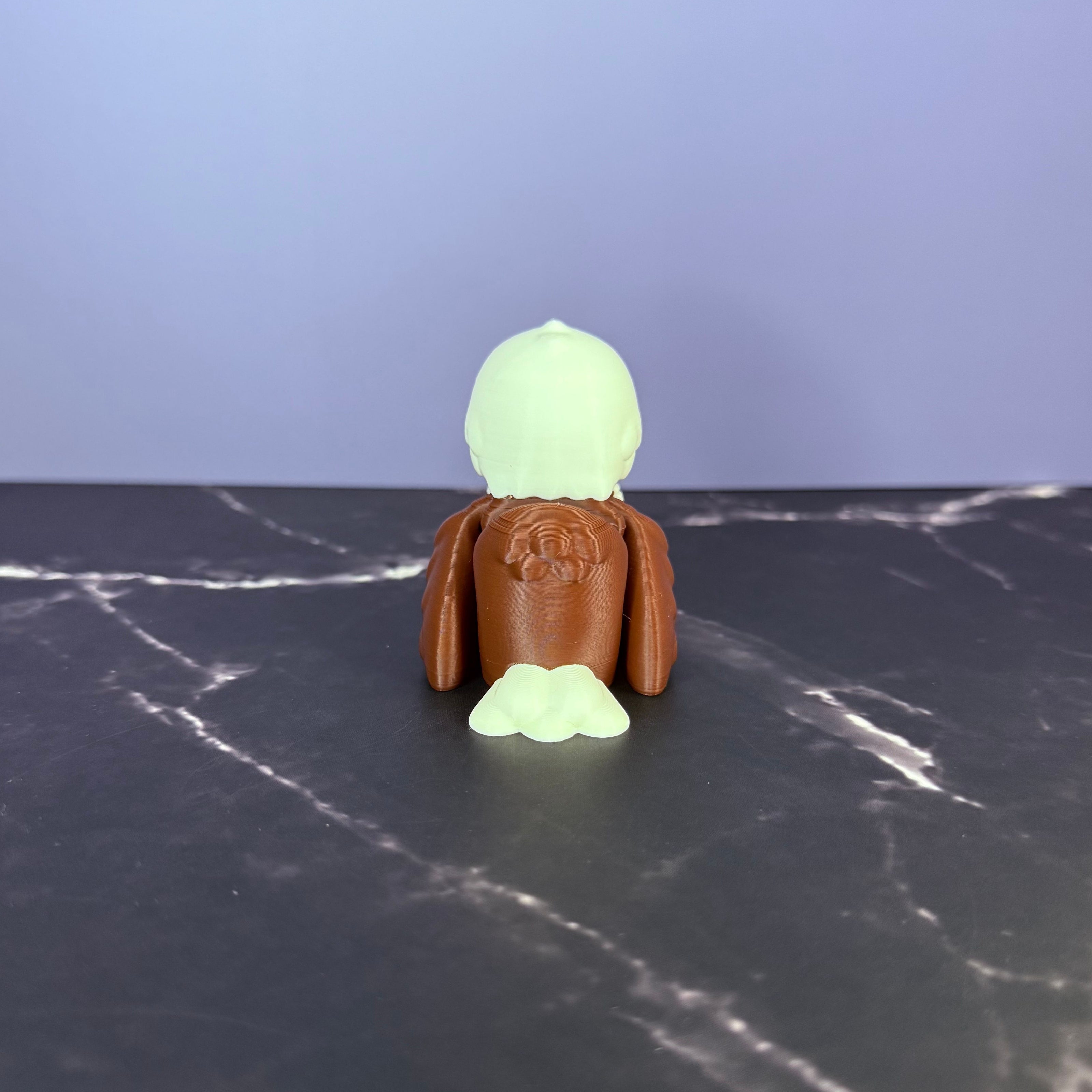 Toy eagle figurine on a dark surface with a light blue and marble black background