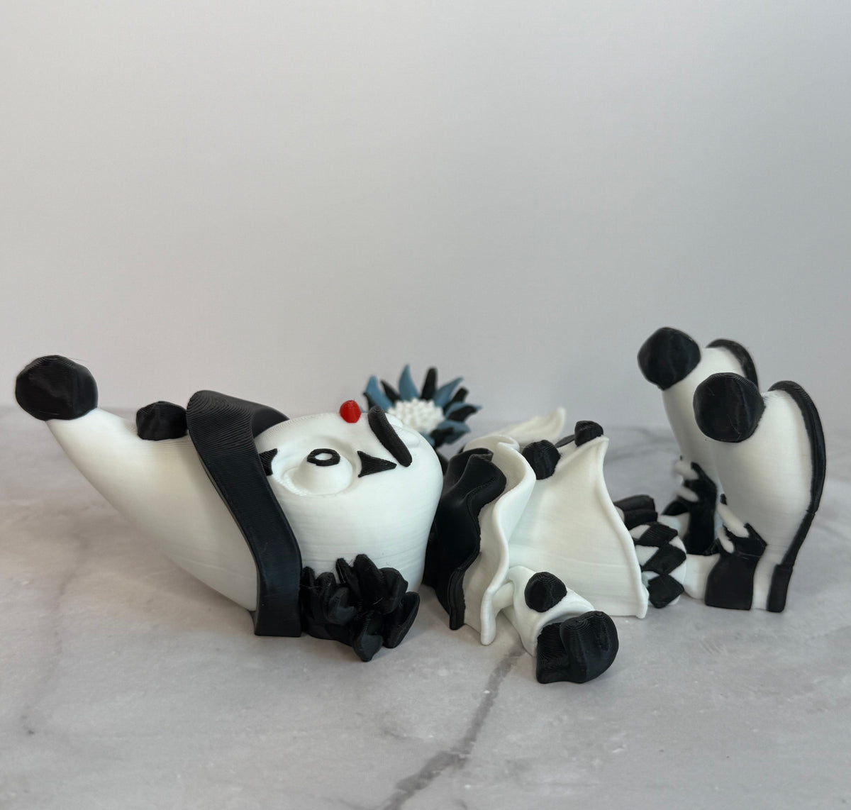 Black and white clown figurine with a hat and checkered outfit on a gray background