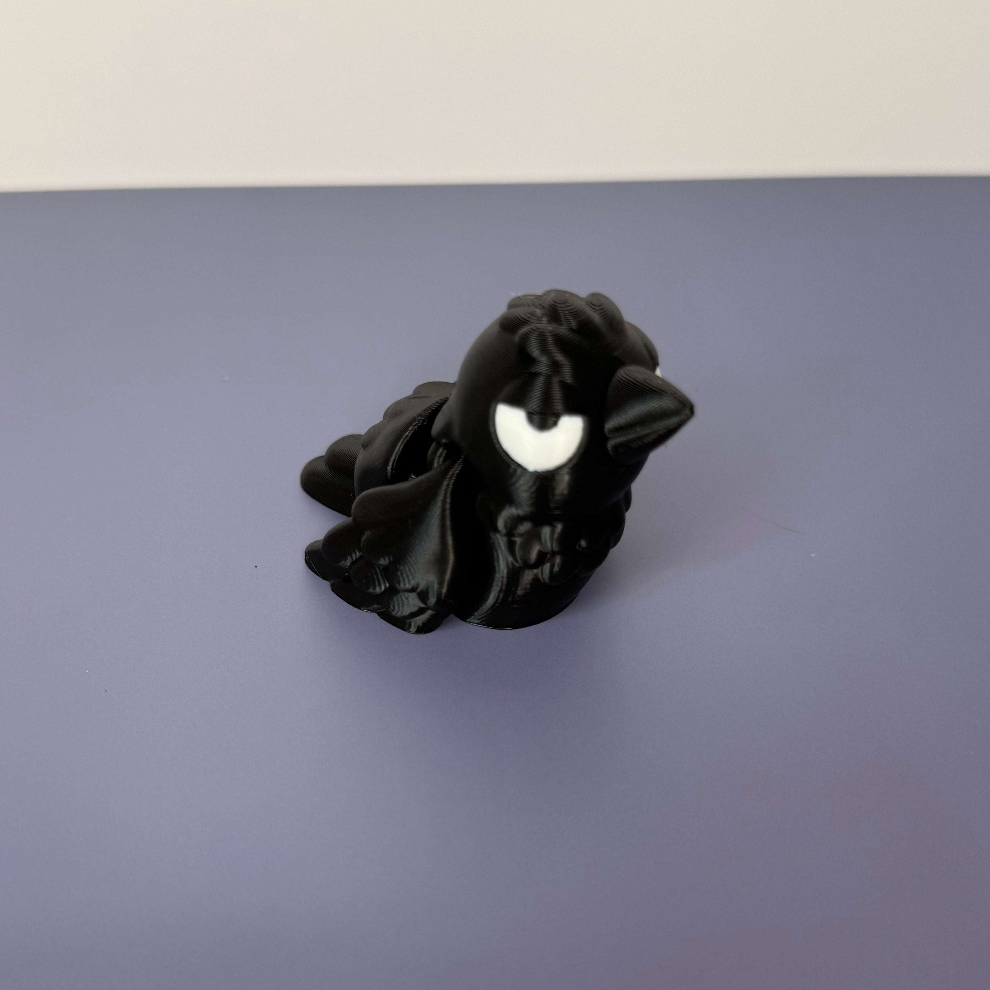 Black crow figure with white eyes on a blue background
