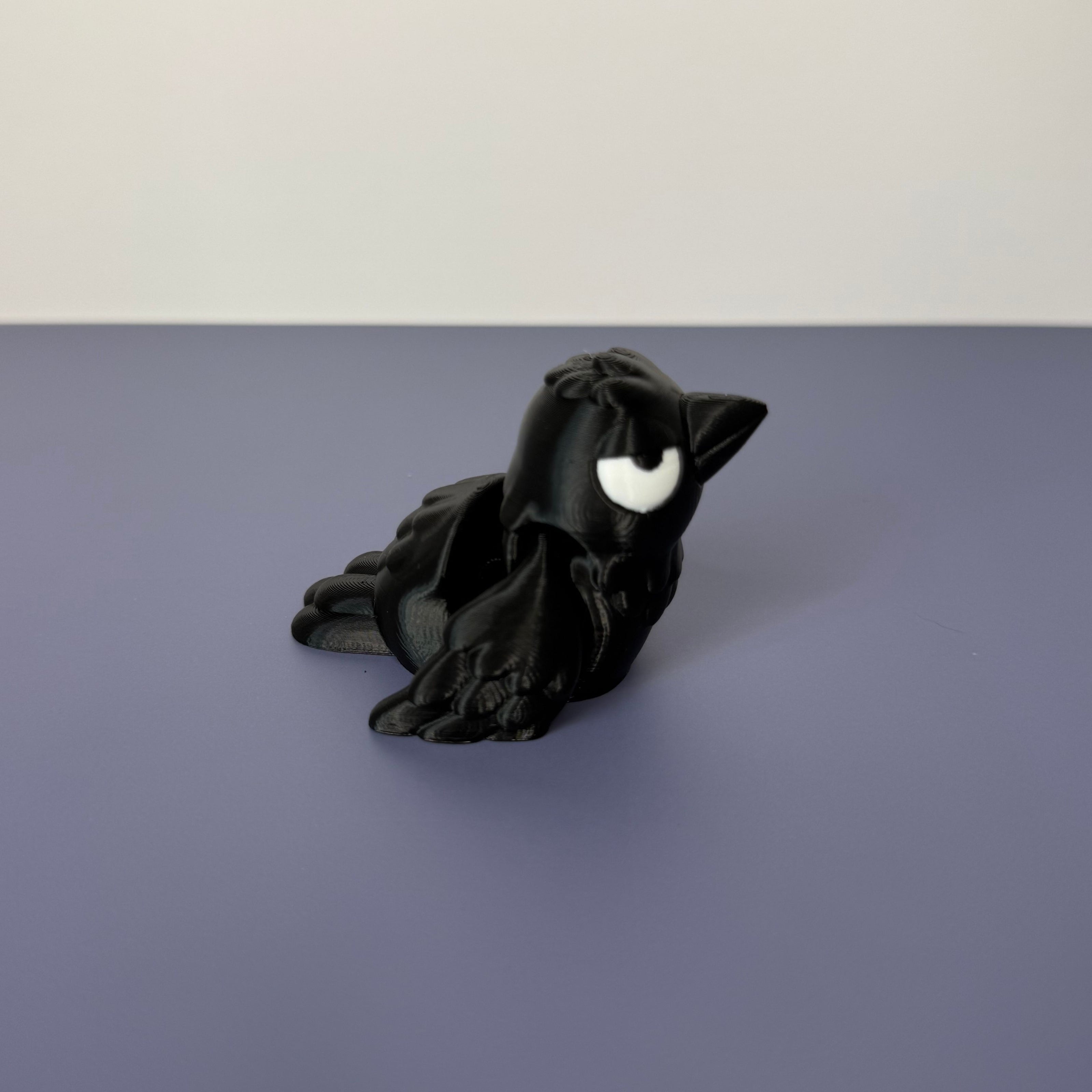 Side of black crow figure with white eyes on a blue background