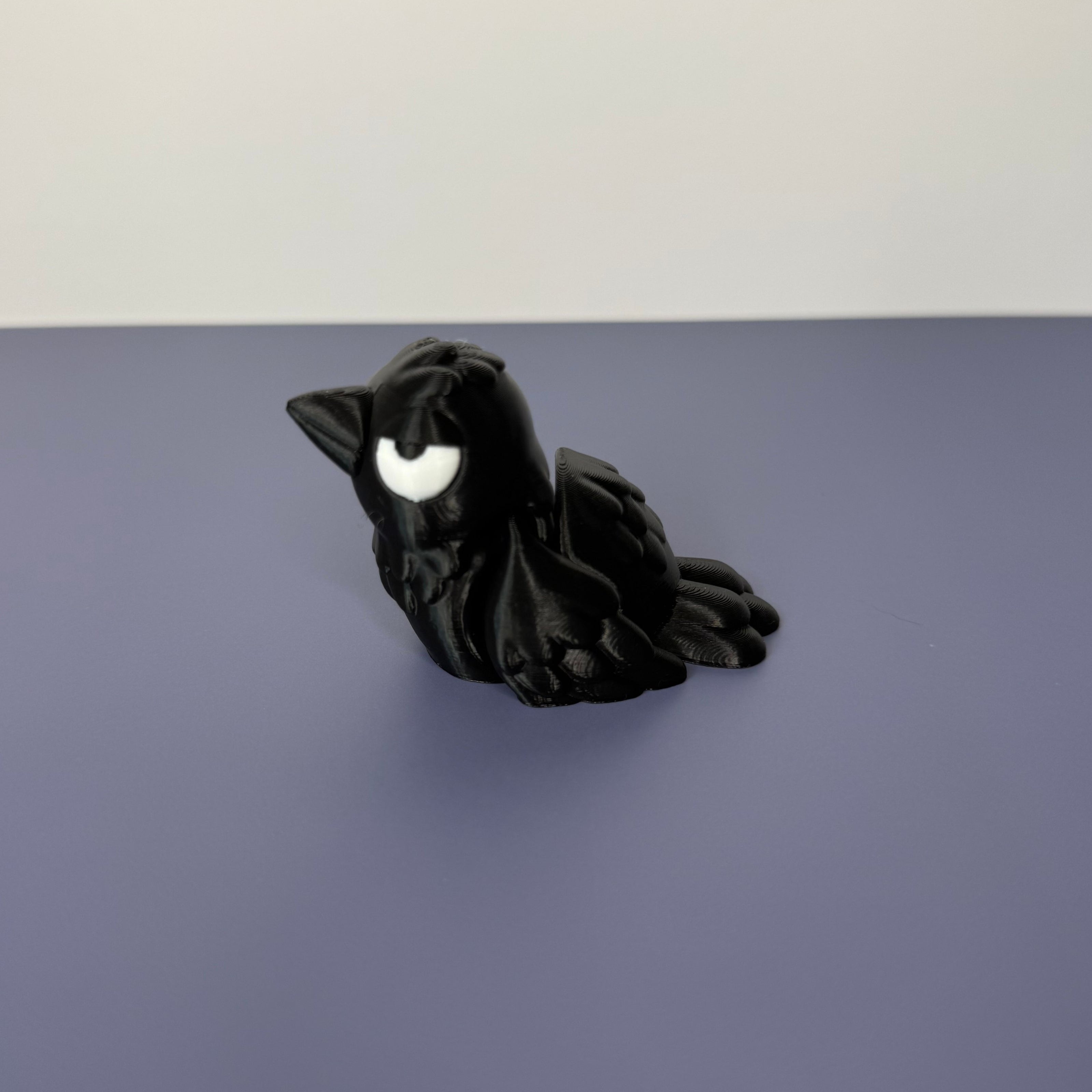 Side of black crow figure with white eyes on a blue background