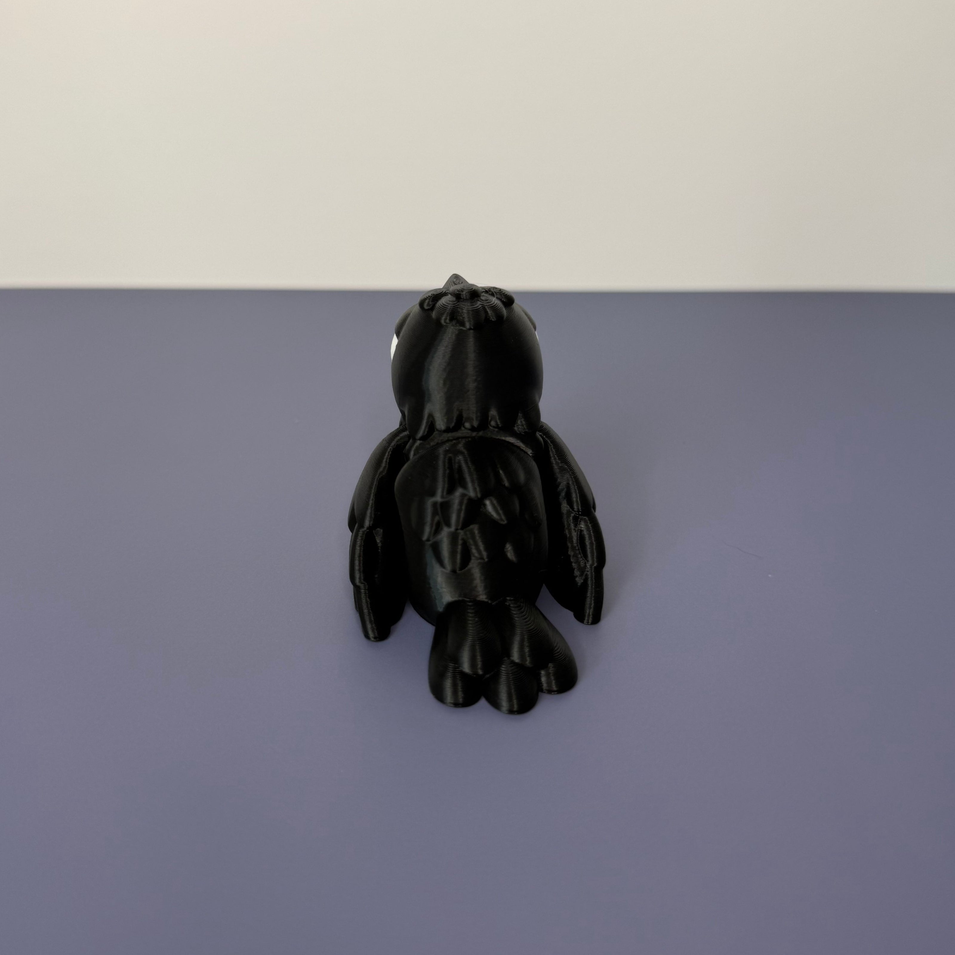 Back of black crow figure on a blue background