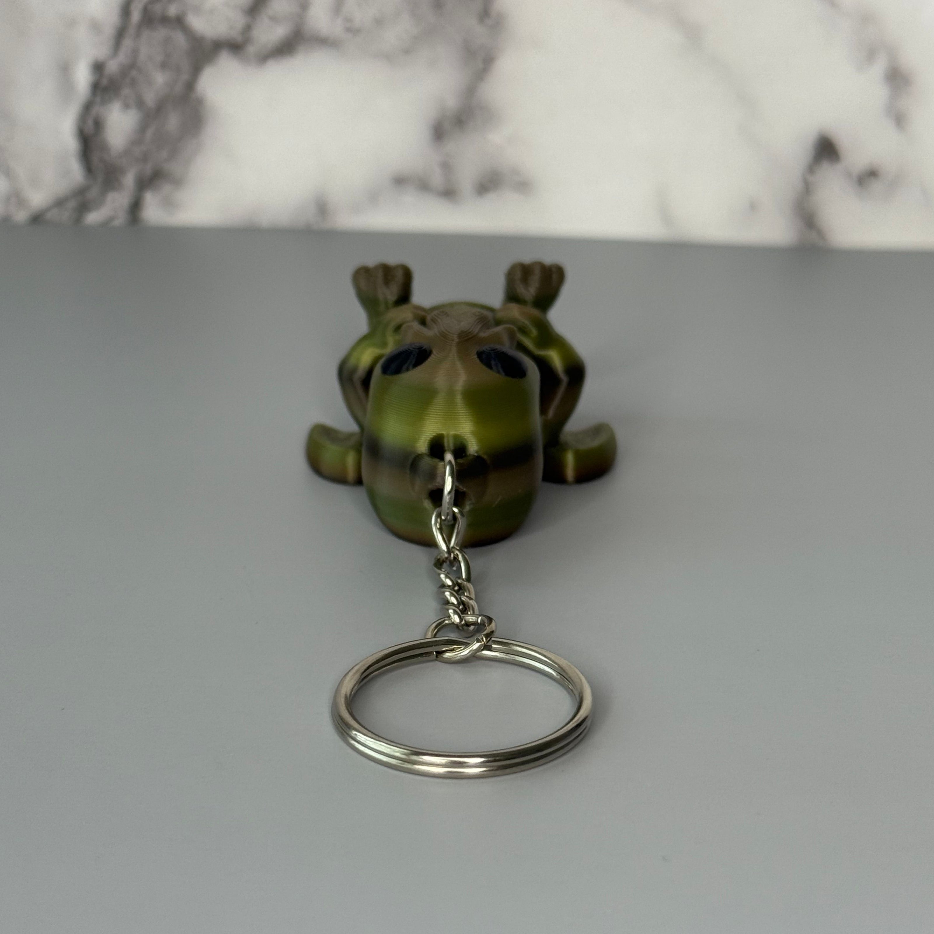 Top of Cthulhu-shaped keychain figure with wings and face-tentacles on a gray background
