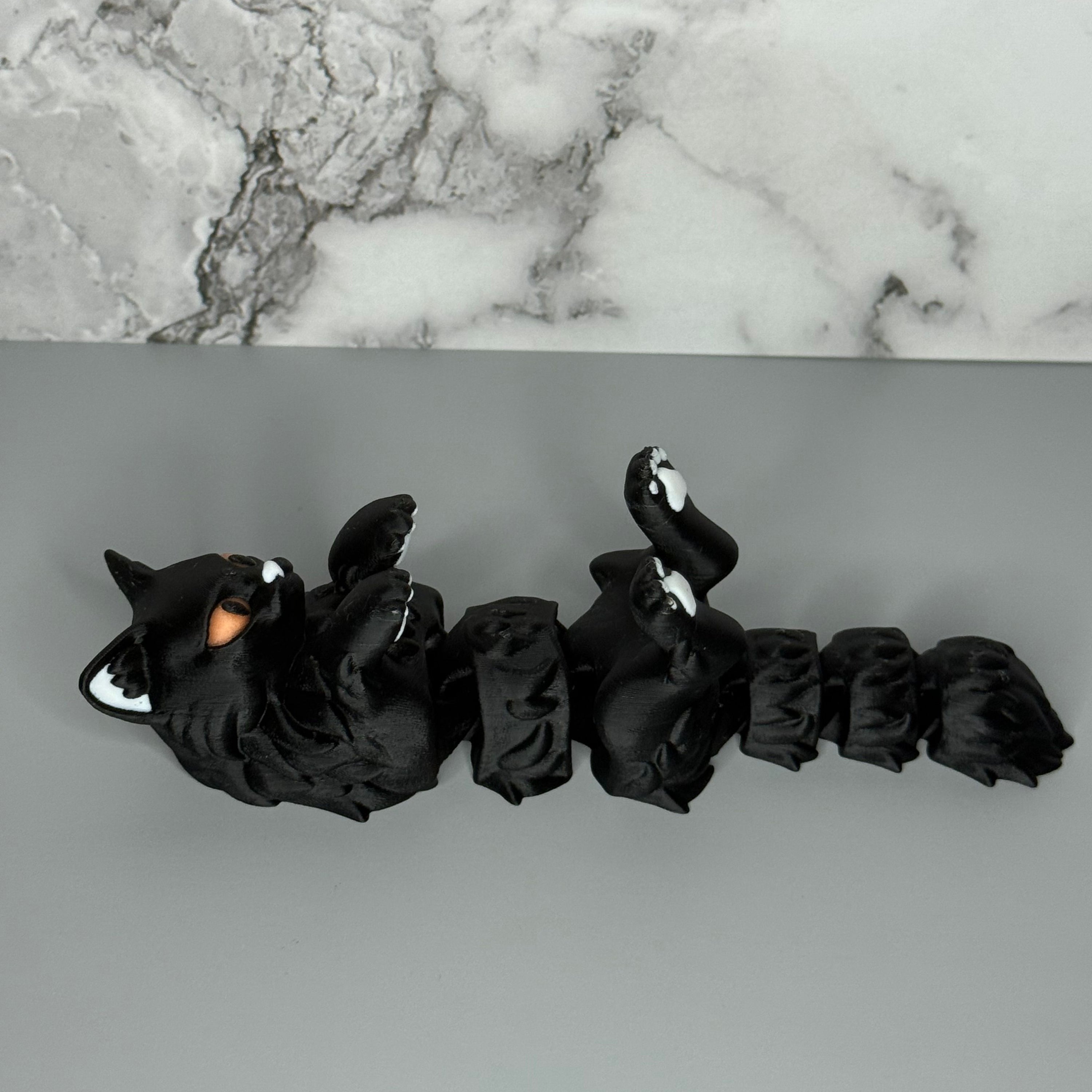 Left side of black cat-shaped figure with orange eyes, white paw pads, and white ears on a gray background