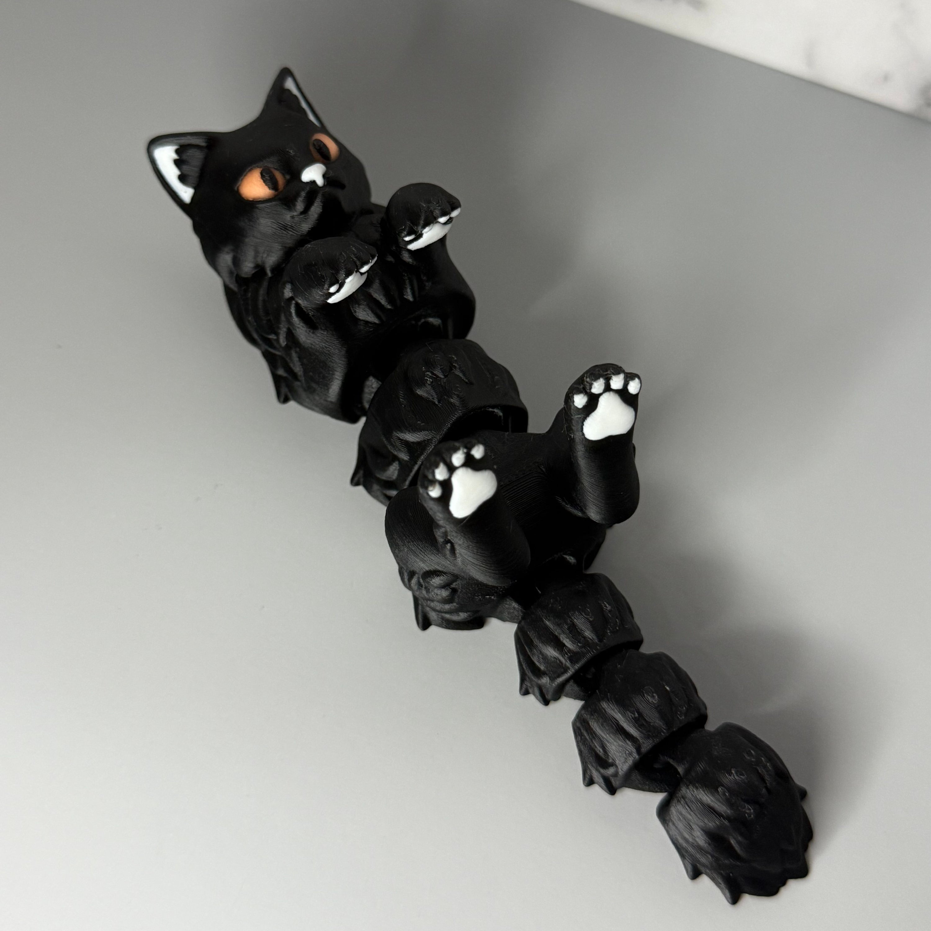 Black cat-shaped figure on a gray and marble surface