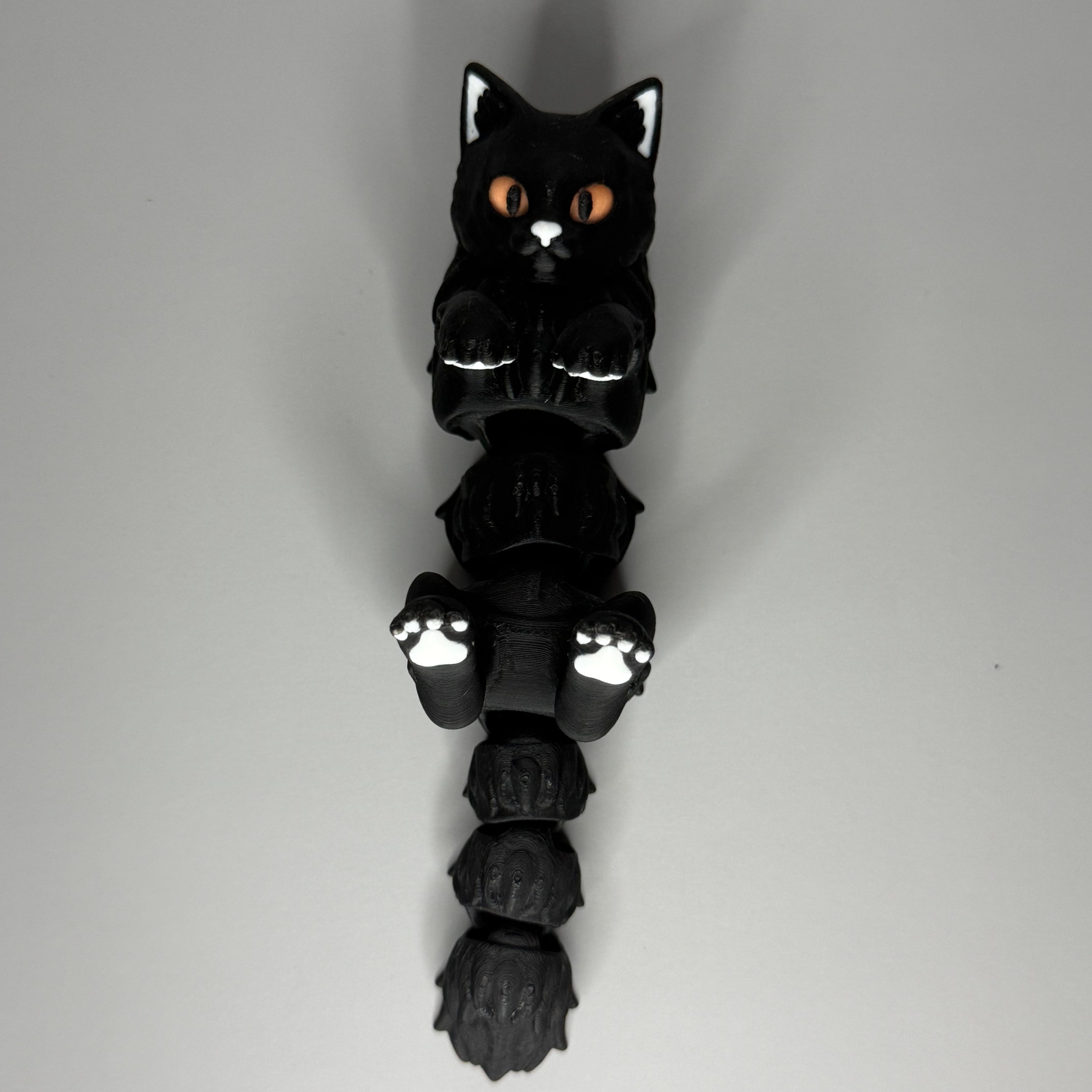 Black cat-shaped figure on a gray surface
