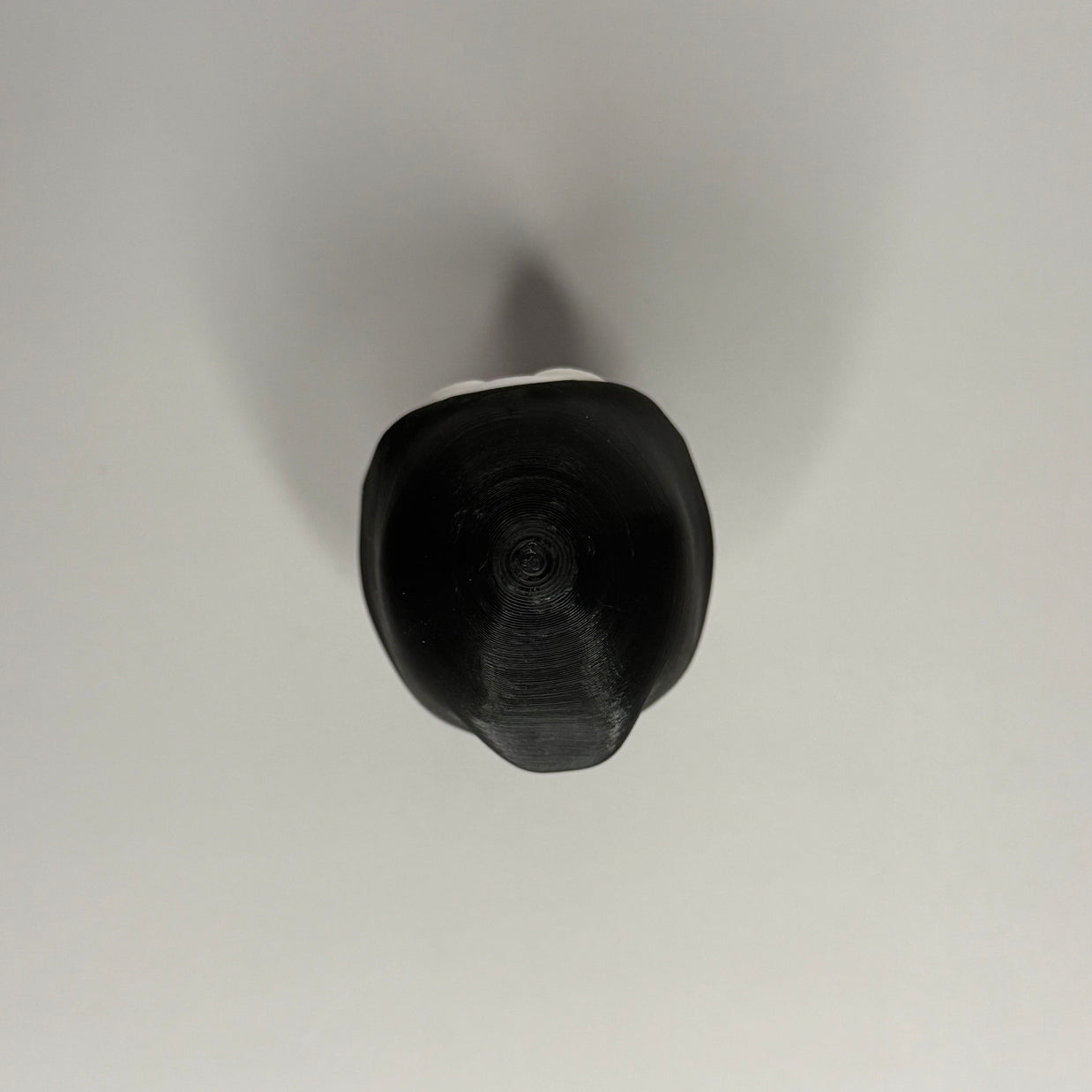 Top side of figure in black robe on a gray background