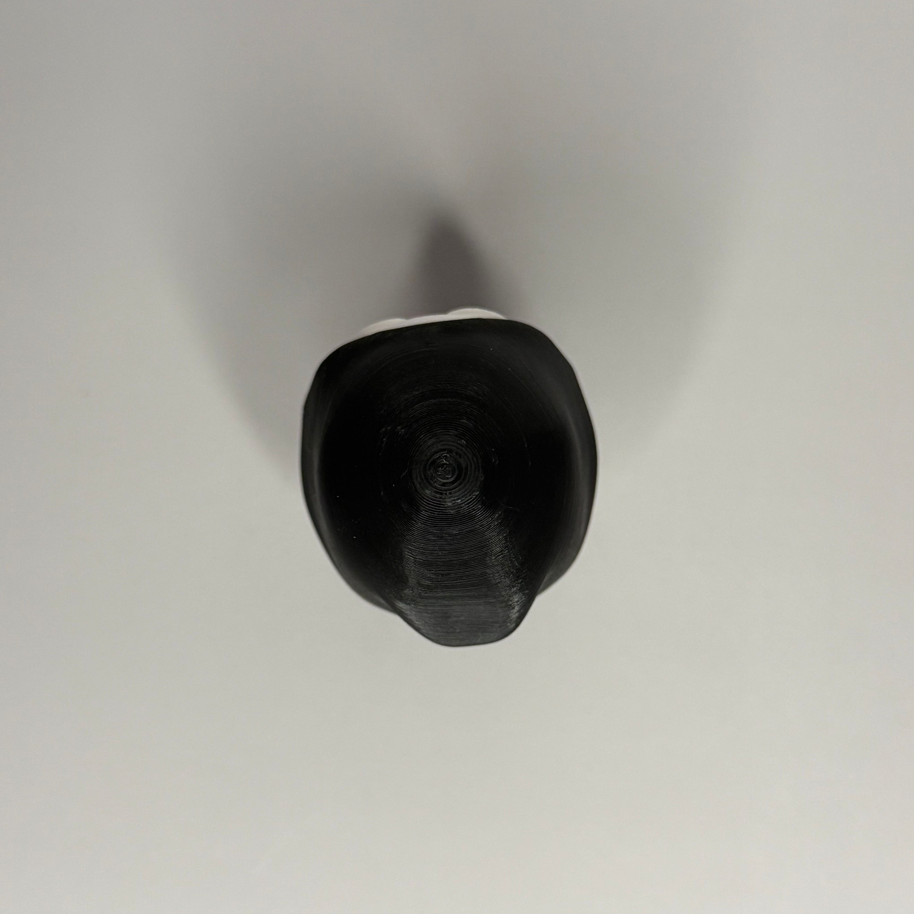 Top side of figure in black robe on a gray background