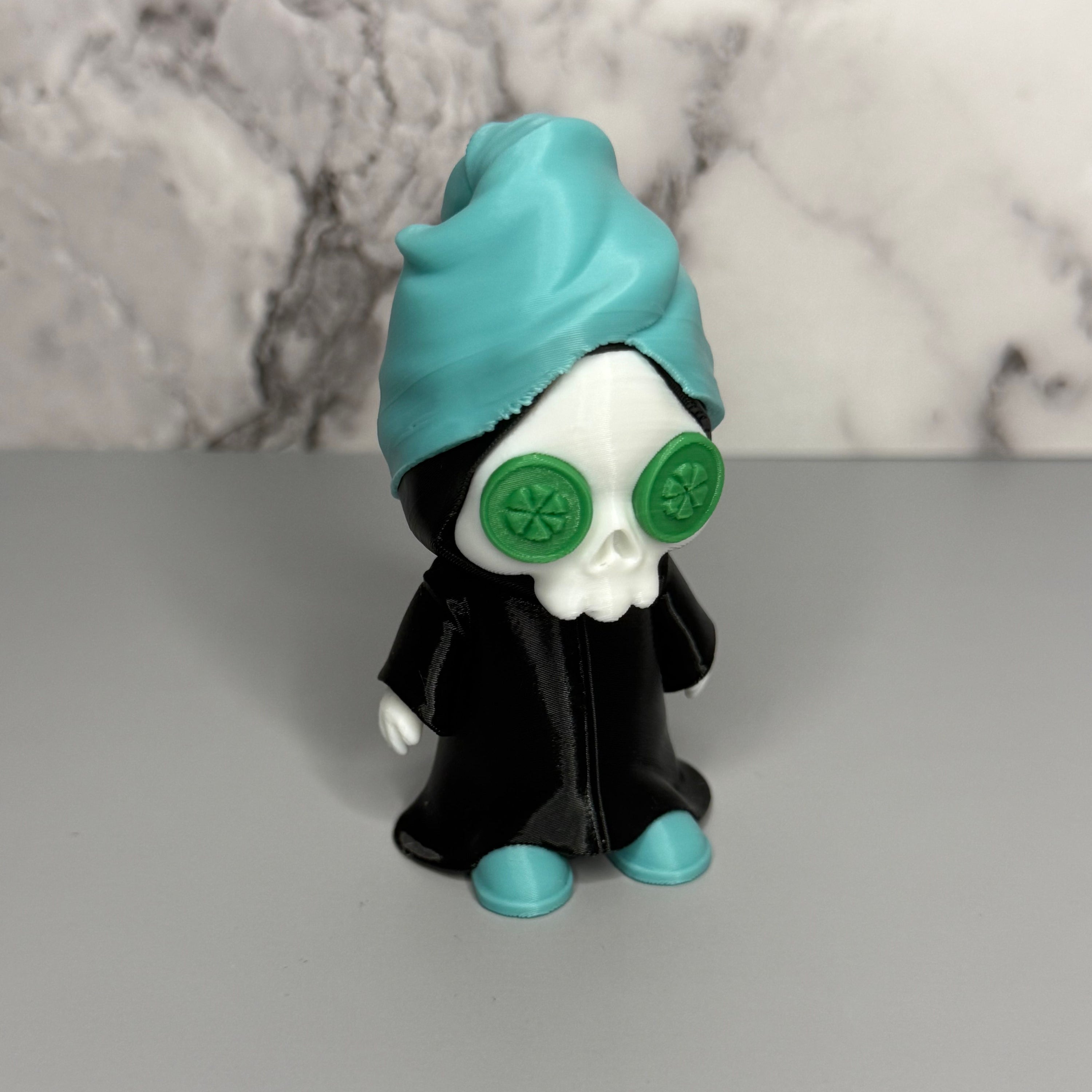 Grim reaper figure with teal head towel and shoes, black cloak, and green discs on eyes on a gray and marble background