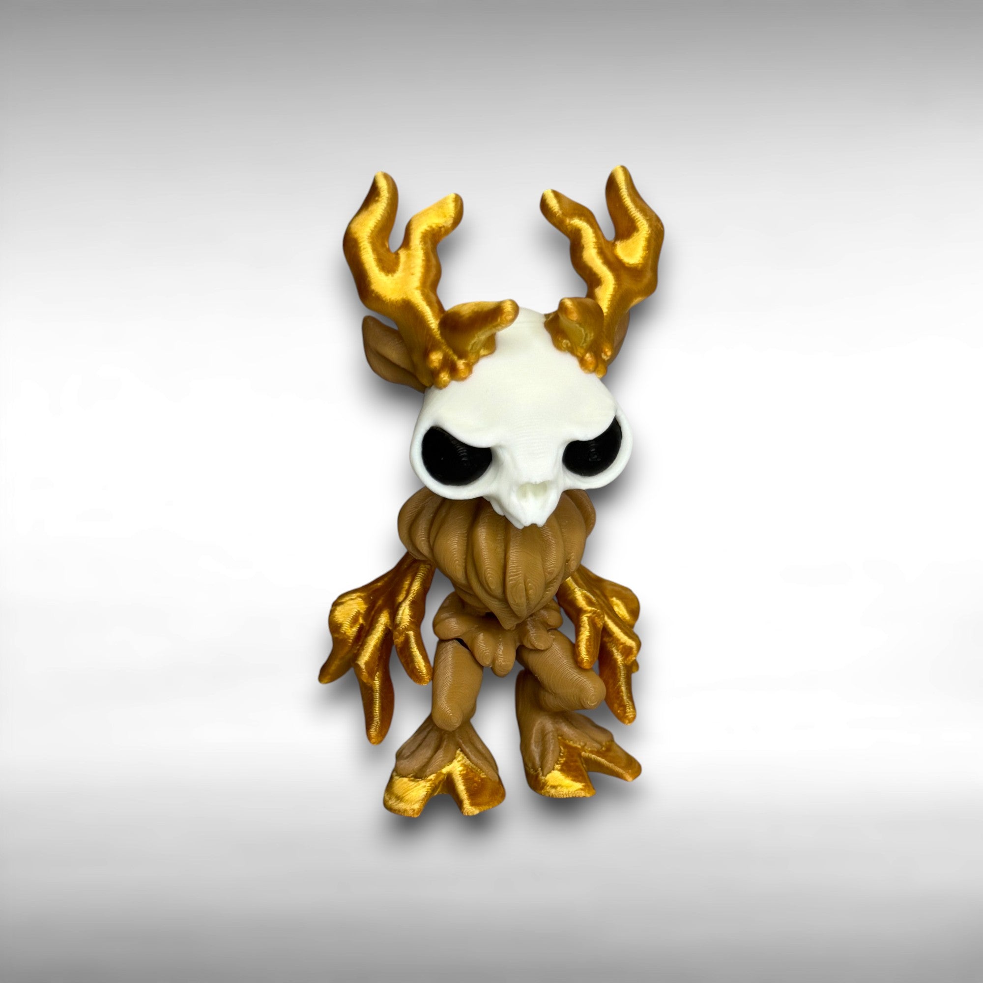 Figure of a wendigo with gold antlers, white face, brown body, and gold hands and hooves on a gray background