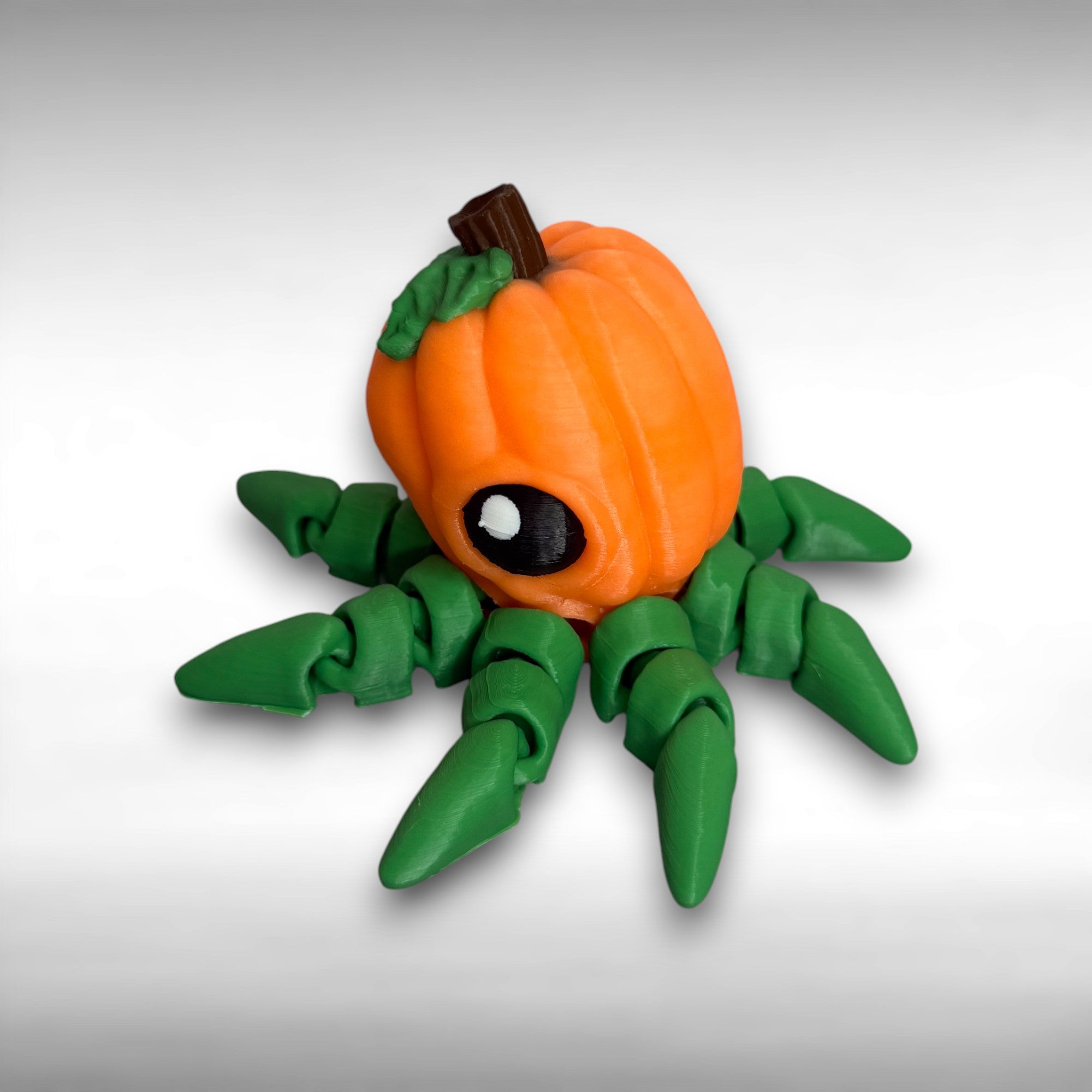 Octopus shaped orange pumpkin figure with green legs on a gray background.
