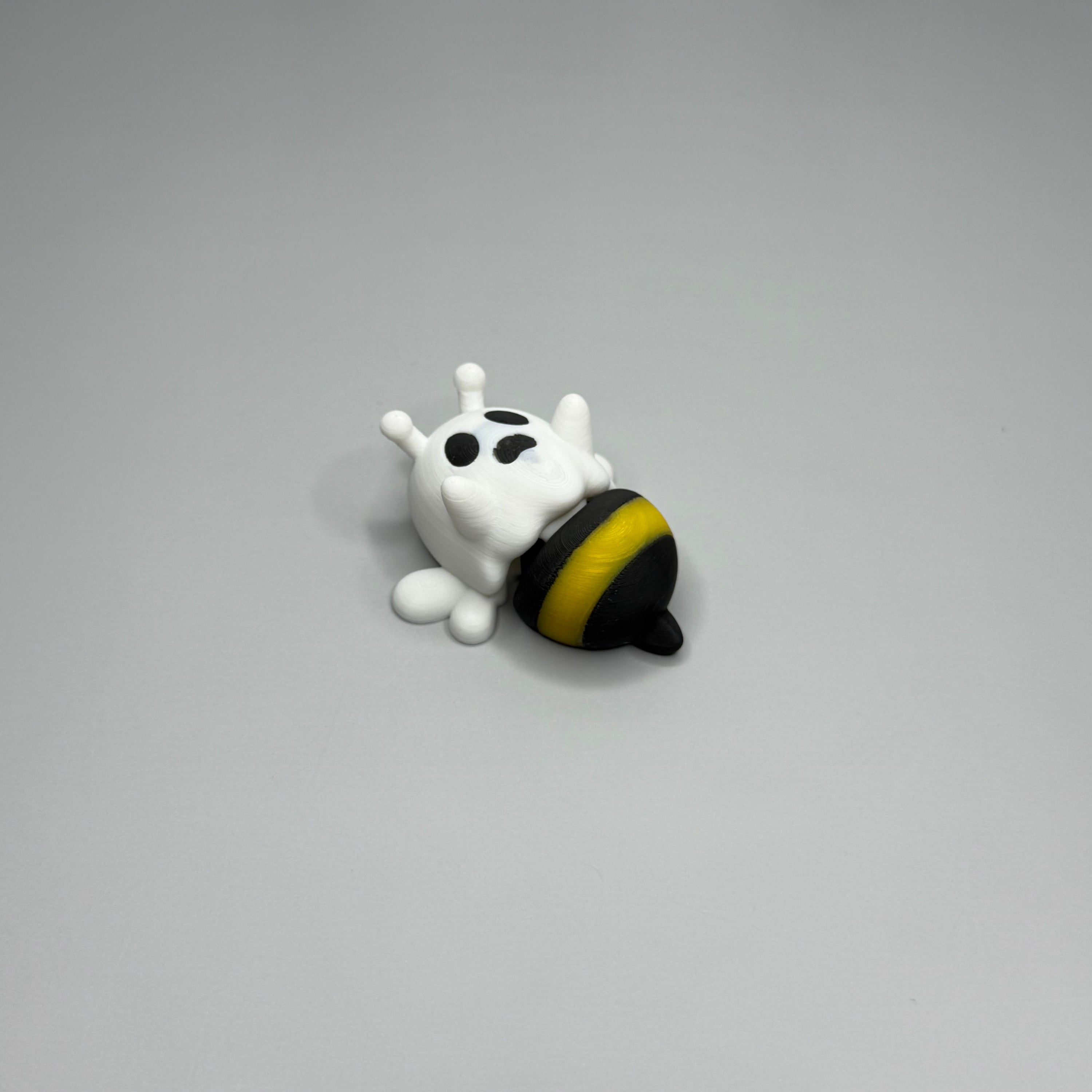 Ghost figure with white wings and a black and yellow bee-shaped lower body on a gray background.