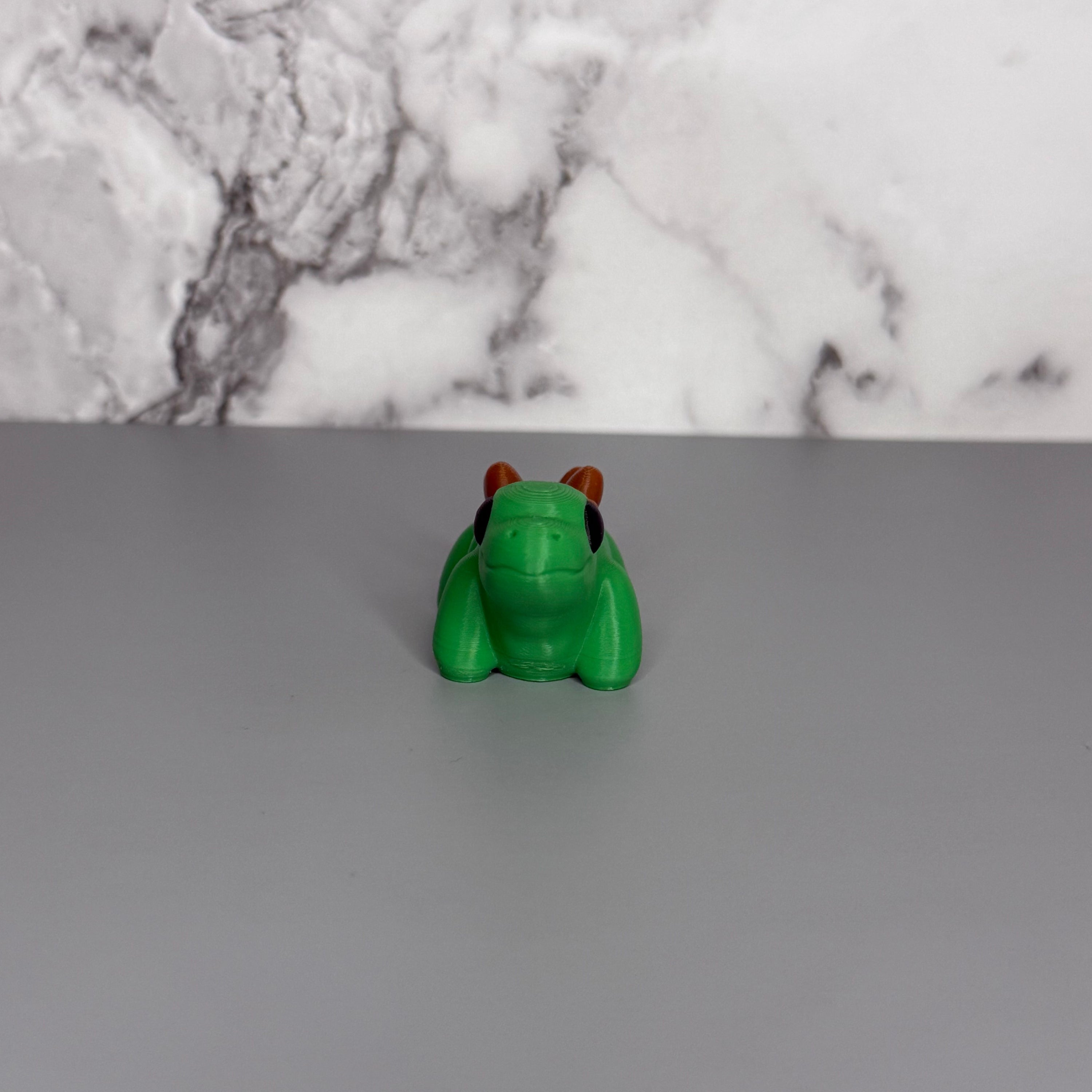 Green dinosaur with brown bumps on its back on a gray marble background