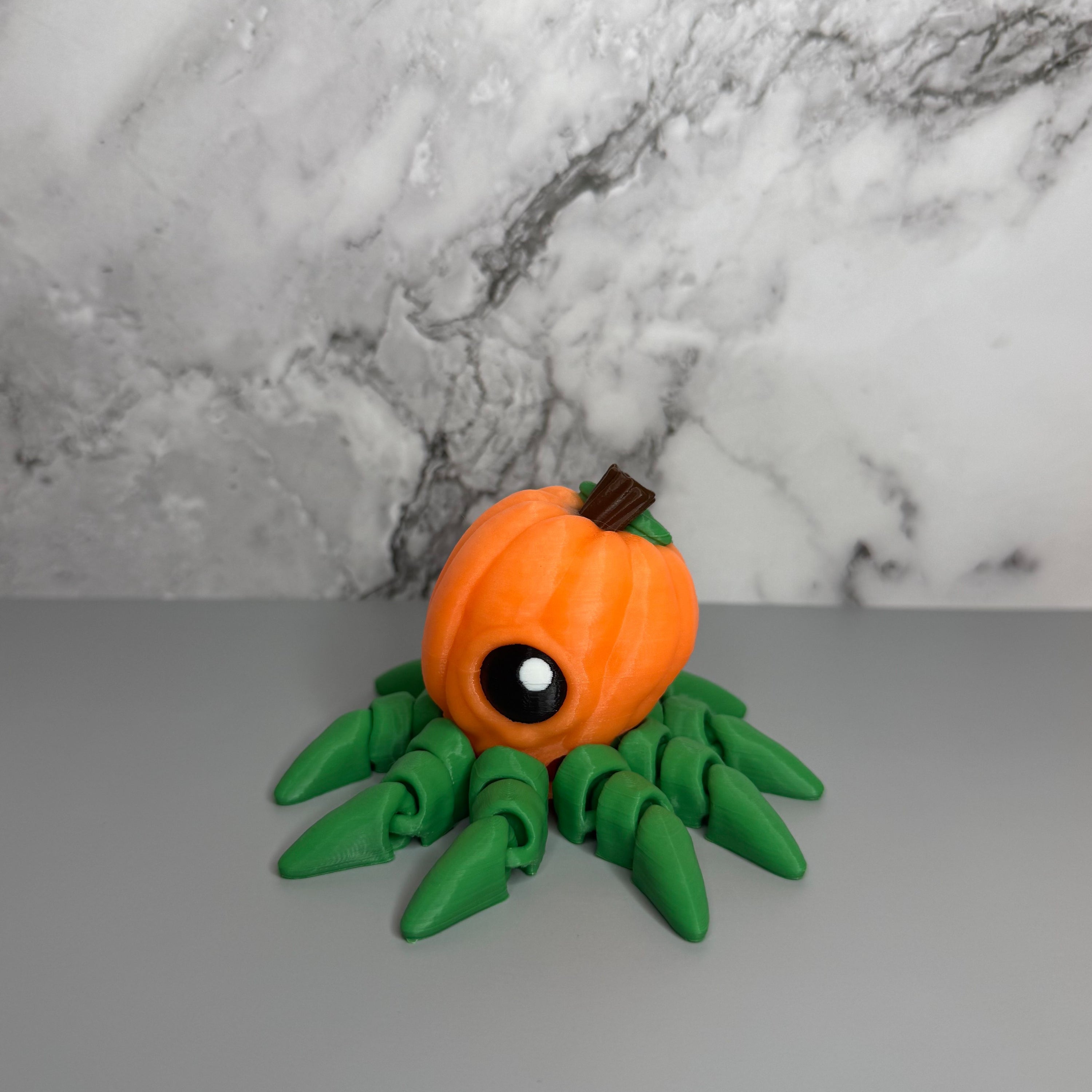 Octopus shaped orange pumpkin figure with green legs on a gray marble background.
