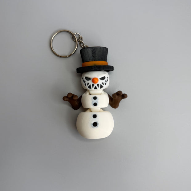 Keychain of a small snowman with a sinister smile with black top hat on a gray background