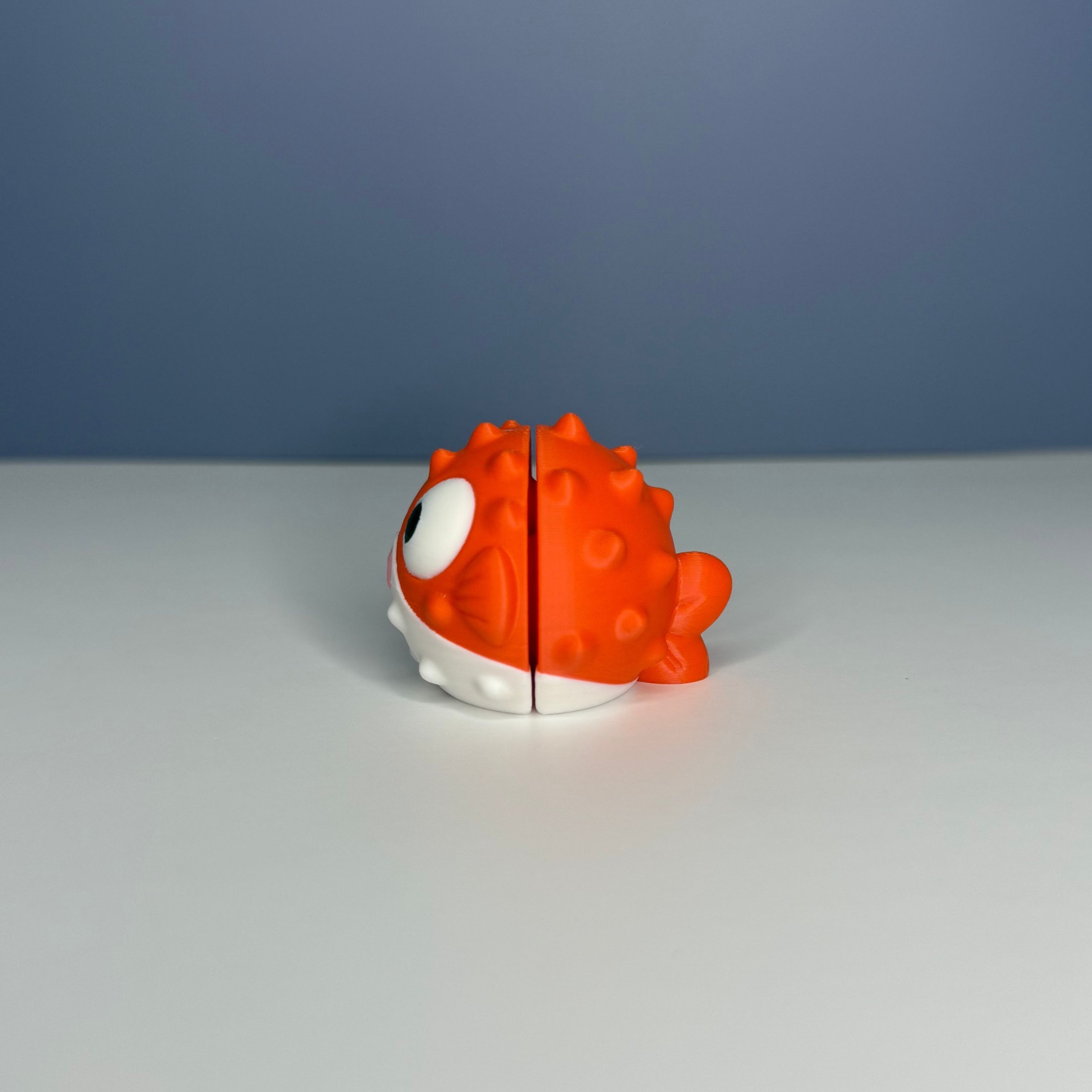 Side of an orange and white puffer fish figure on a blue and white background