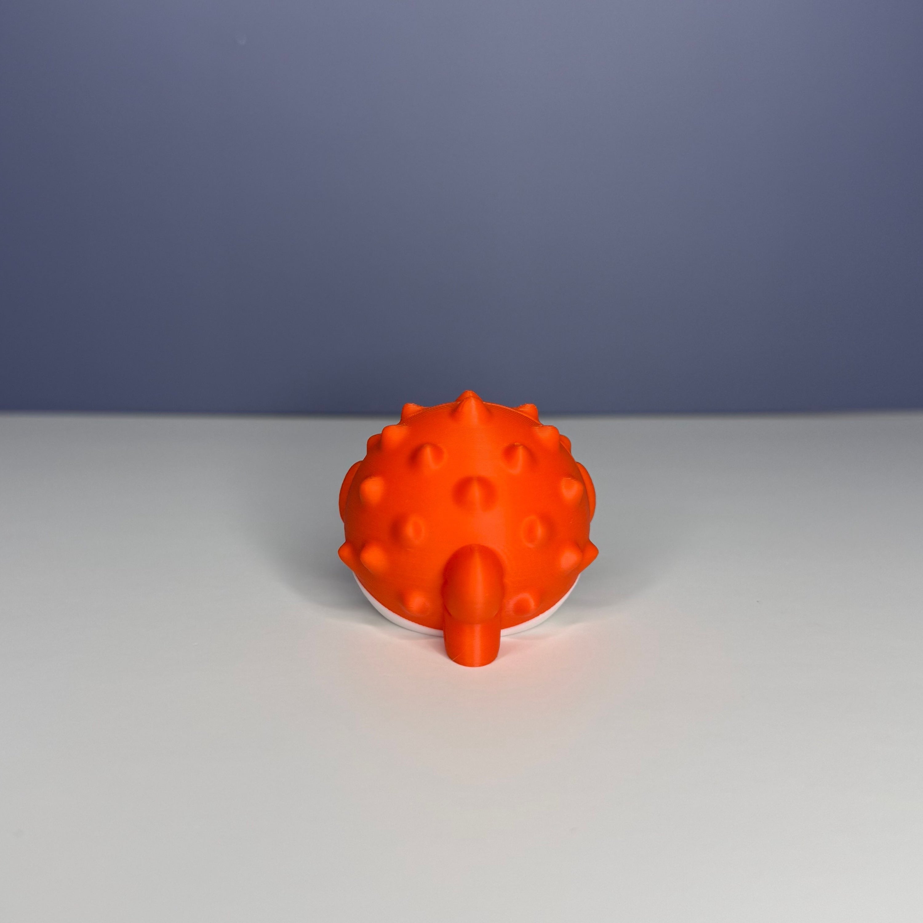 Backside of an orange and white puffer fish figure on a blue and white background
