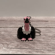 Keychain shaped like a cartoon vulture on a wooden surface