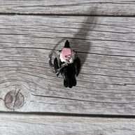 Top side of a keychain shaped like a cartoon vulture on a wooden surface 