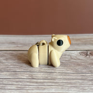 side of a 3D printed beige capybara-shaped keychain on a wooden surface