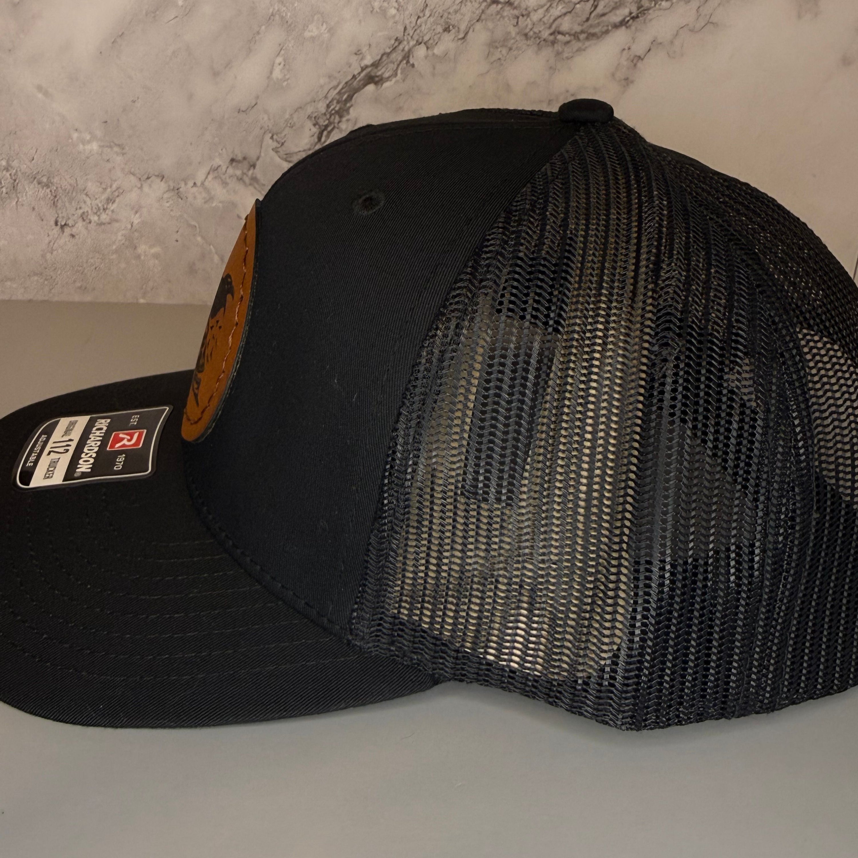 Black mesh cap with a brand label on a light gray surface