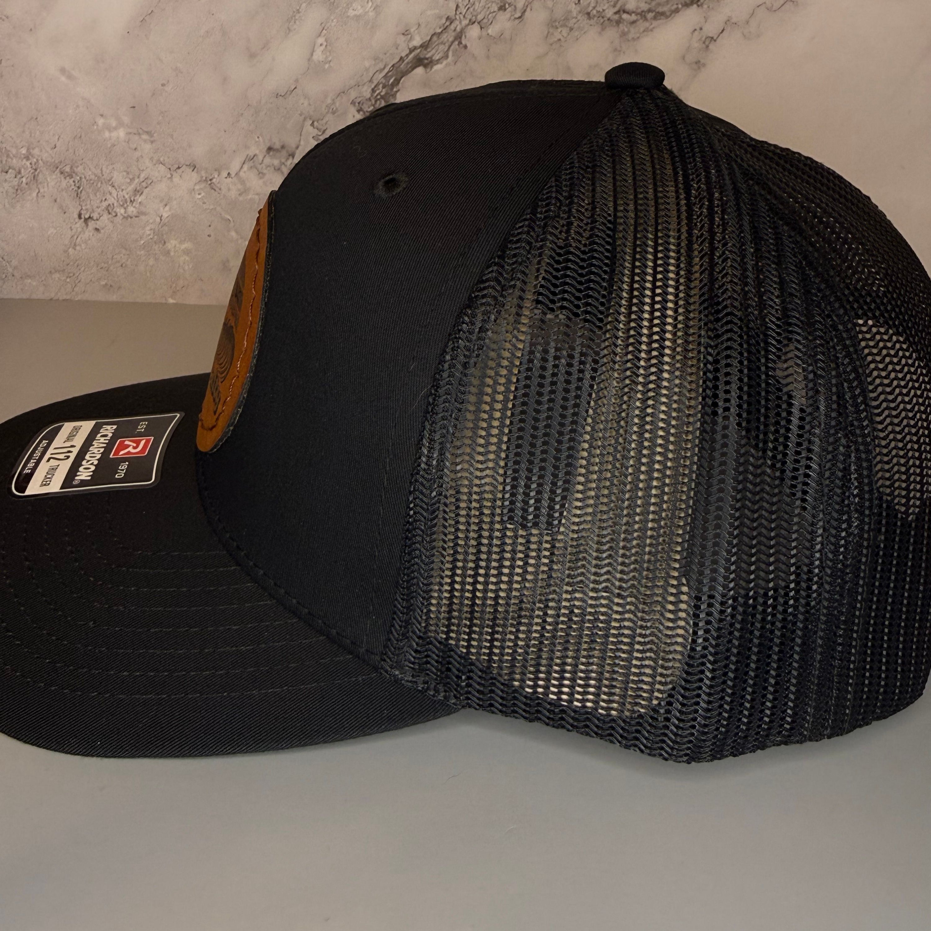 Black mesh cap with Reebok label on a gray surface
