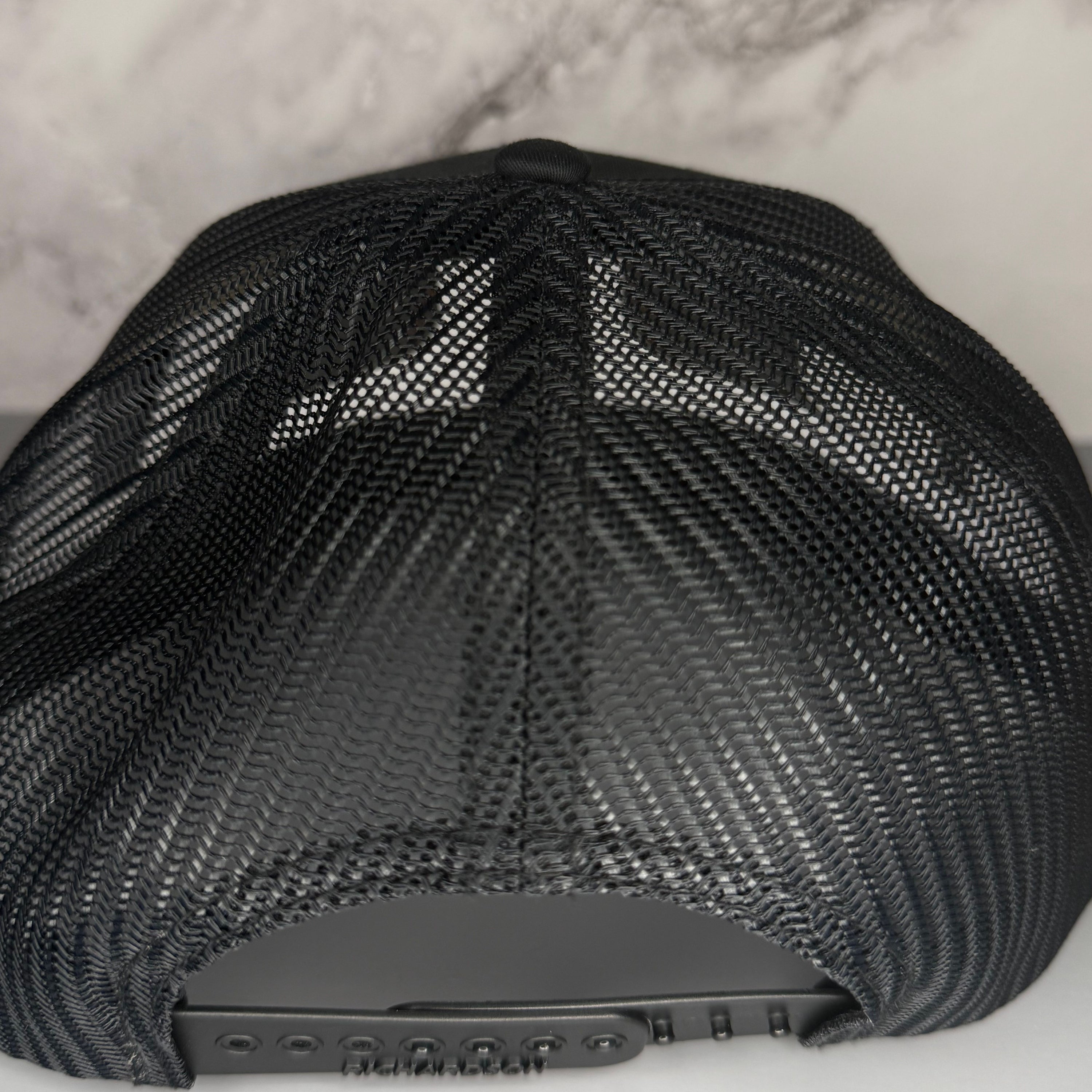 Black mesh cap on a light gray background