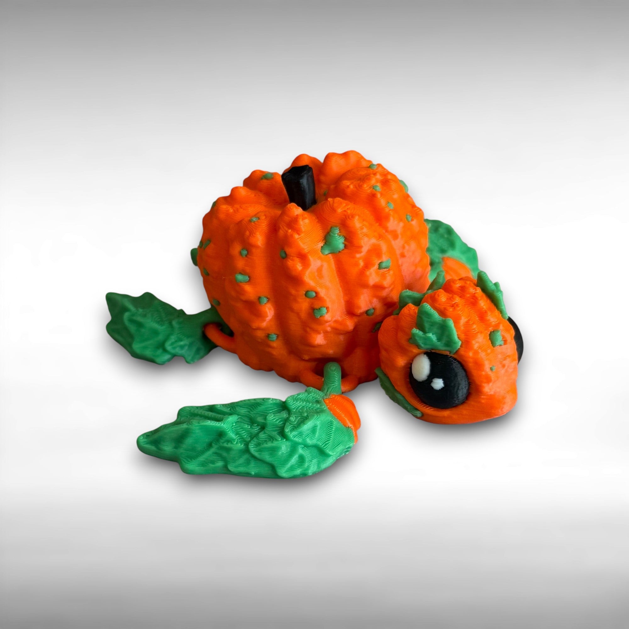 3D printed pumpkin-shaped turtle figure with leaf-like flippers against a gray background