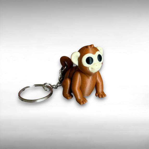 3D printed brown monkey-shaped keychain on a white background