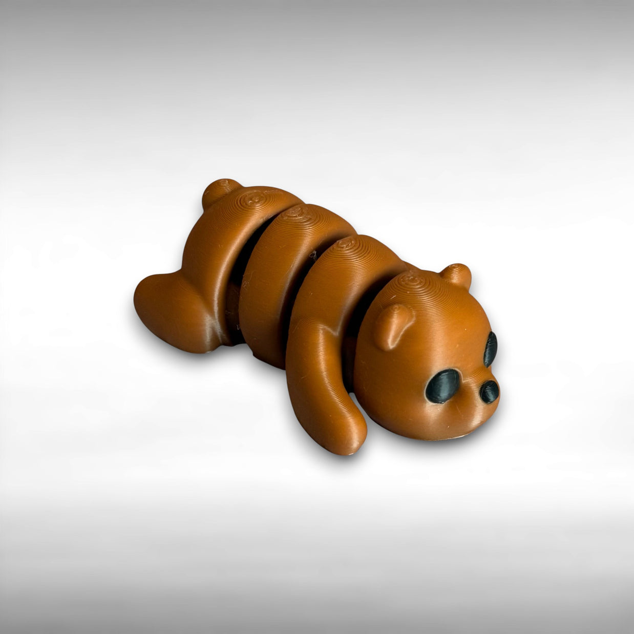 3D printed brown bear-shaped keychain on a light gray background