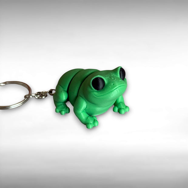 3D printed green frog-shaped keychain on a white background