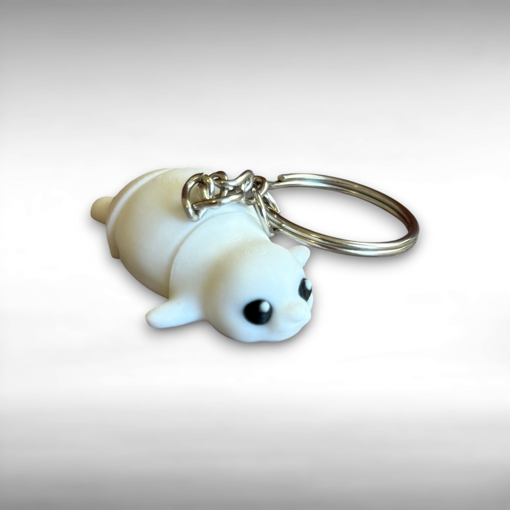 3D printed white seal-shaped keychain against a white background