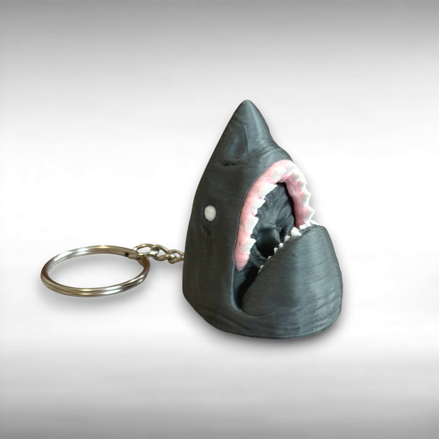 3D printed gray shark-head keychain against a white background