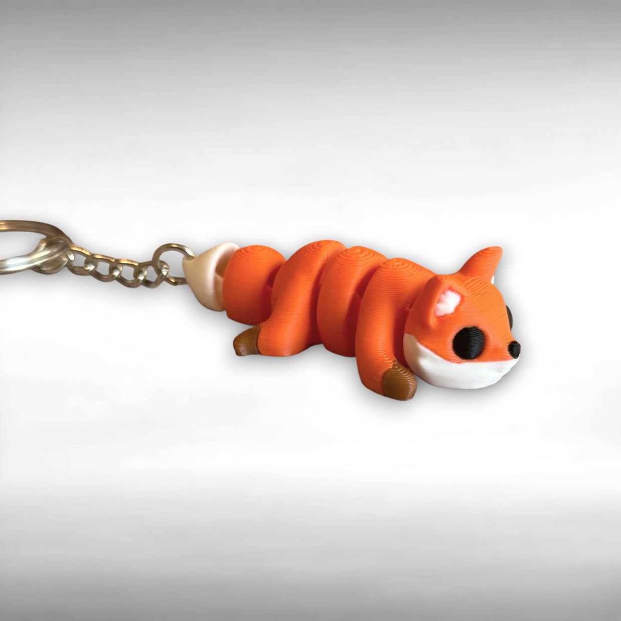 3D printed orange fox-shaped keychain on a white background