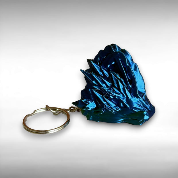 3D printed blue and green jellyfish-themed dragon head keychain against a white background