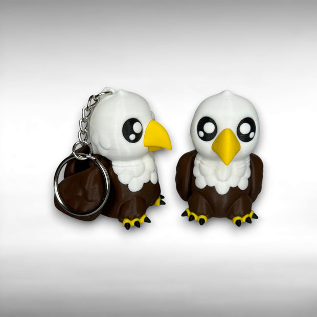 Two cartoon-style eagle keychains on a white background